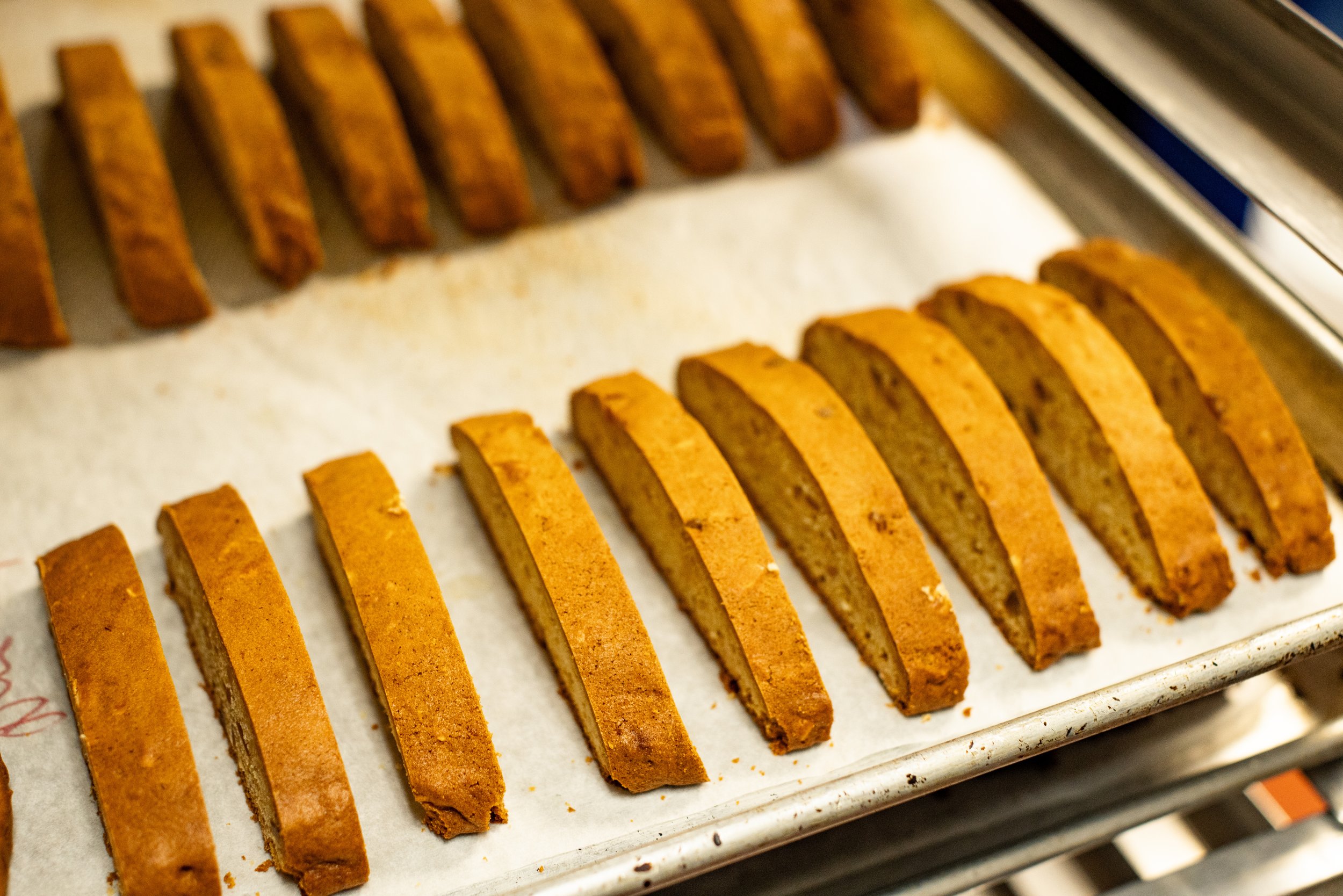 Slices of banana bread cooling on a baking sheet lined with parchment paper.