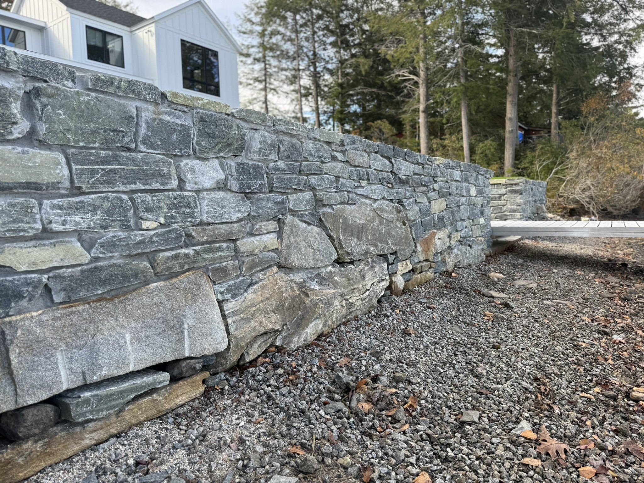 In the spring and fall, when water levels recede in the reservoir, a skilled mason undertakes excavation to prepare the site for constructing a magnificent lake wall. This meticulously planned wall is intended to safeguard the surrounding land from e