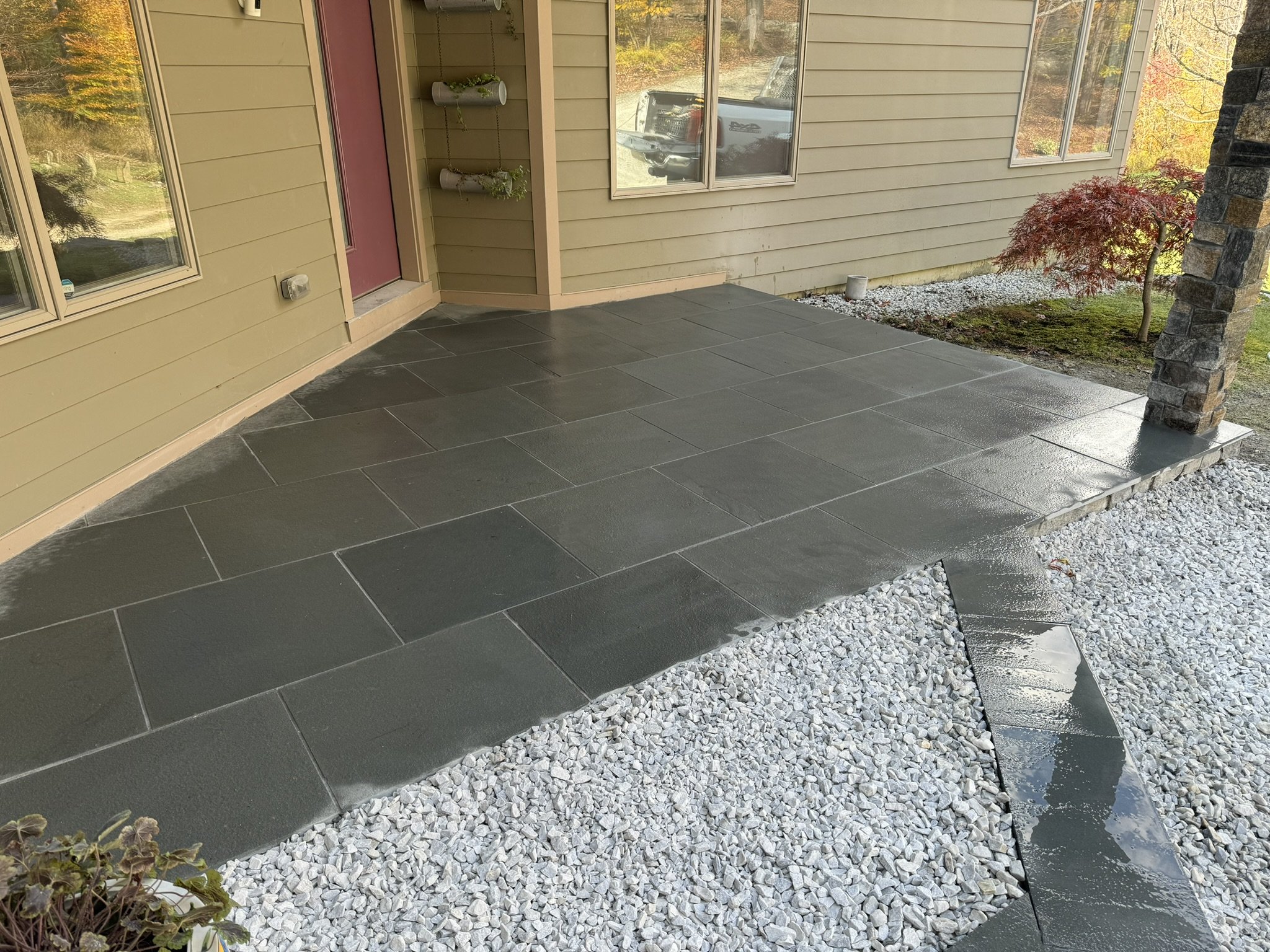 The combination of bluestone and white decorative rock lends a clean upscale appearance to the entrance, creating a subtle yet distinctive ambiance 