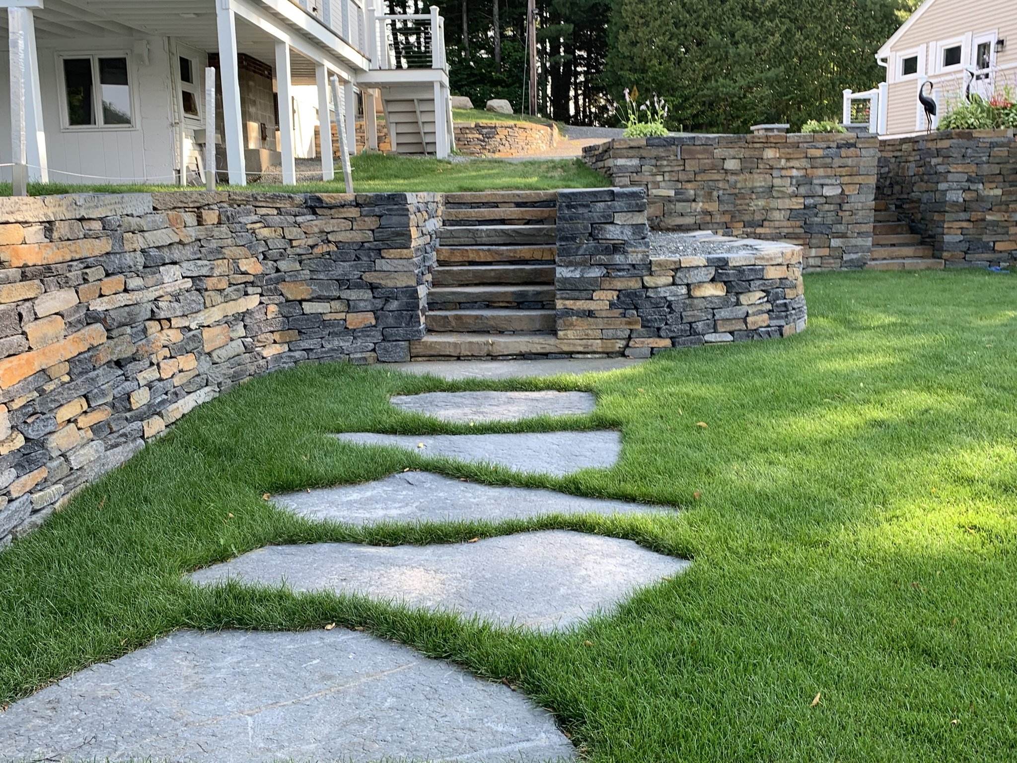 Large walk stones leading to goshen stone staircase with crisp walls and freshly placed sod