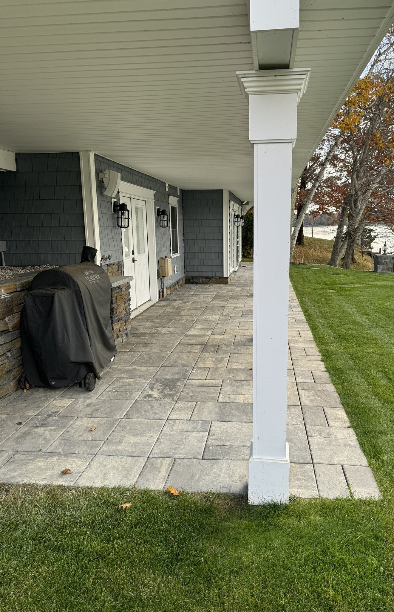 Crisp concrete pavers form a clean foundation beneath the deck, creating a contemporary and organized outdoor space.  The smooth surface of the pavers contrasts with the vibrant green of freshly laid sod, enhancing the overall visual appeal 