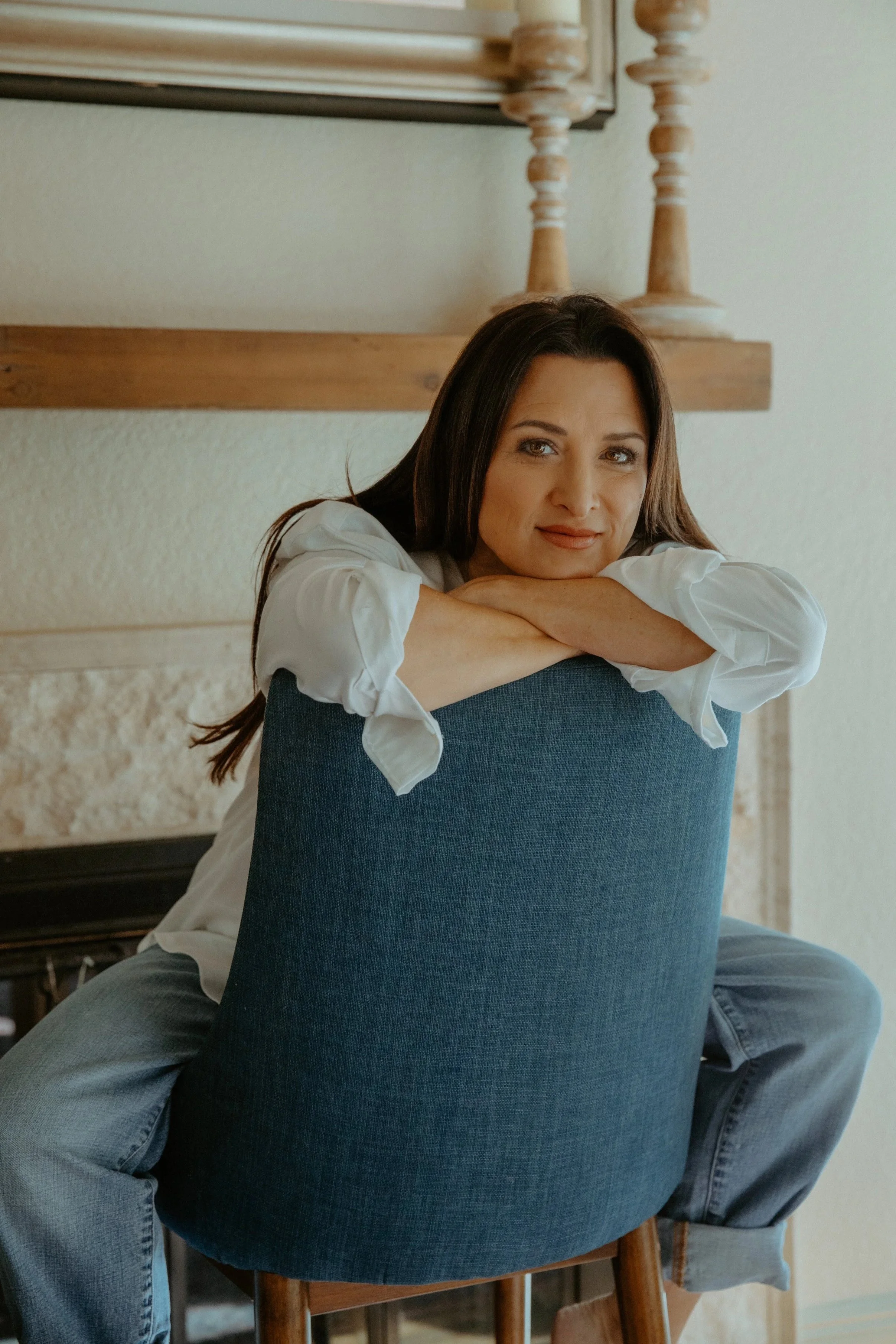 Lifestyle branding photo of woman leaning on chair in bright, modern home setting