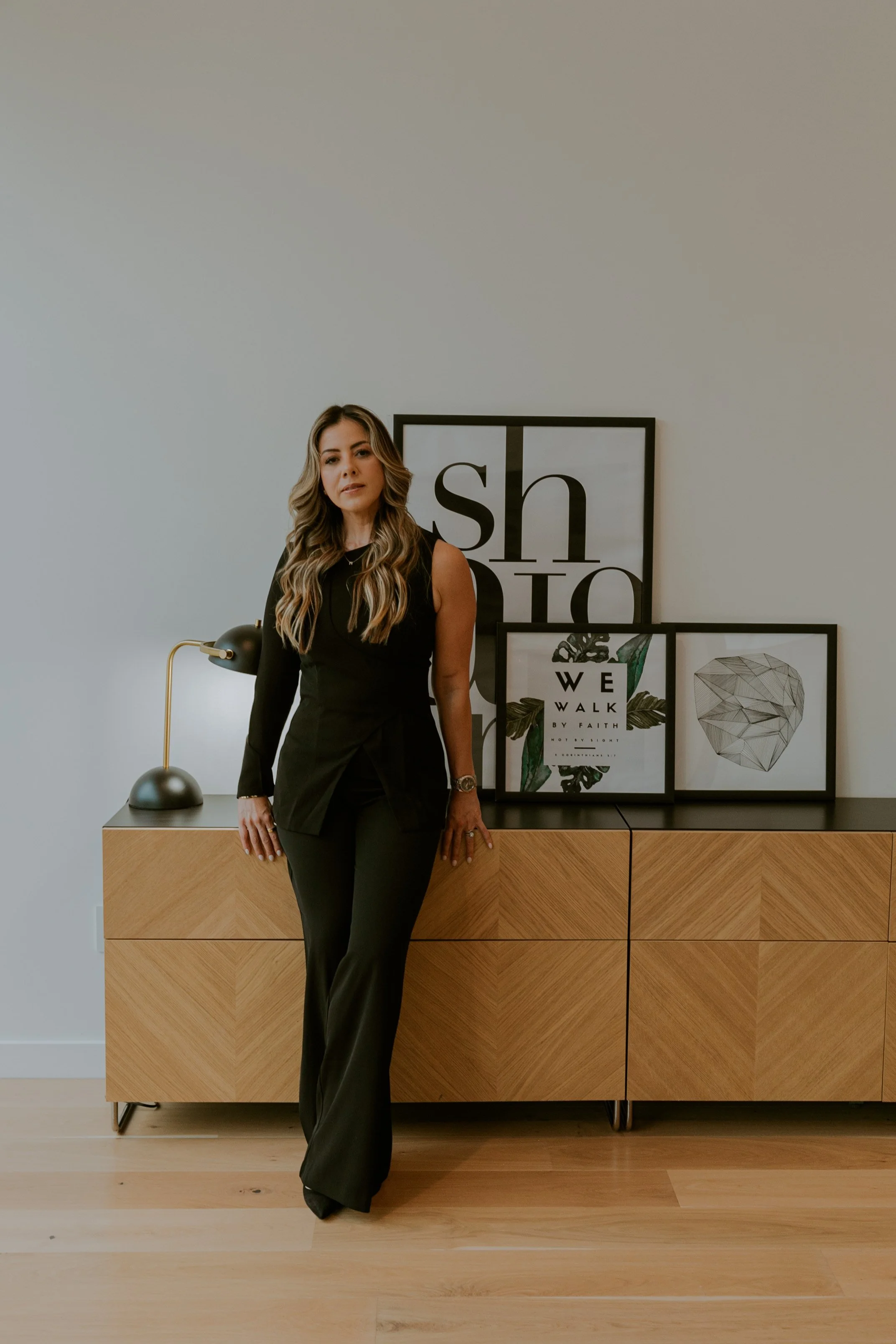 Orlando branding session with woman standing in modern interior with framed artwork and natural light