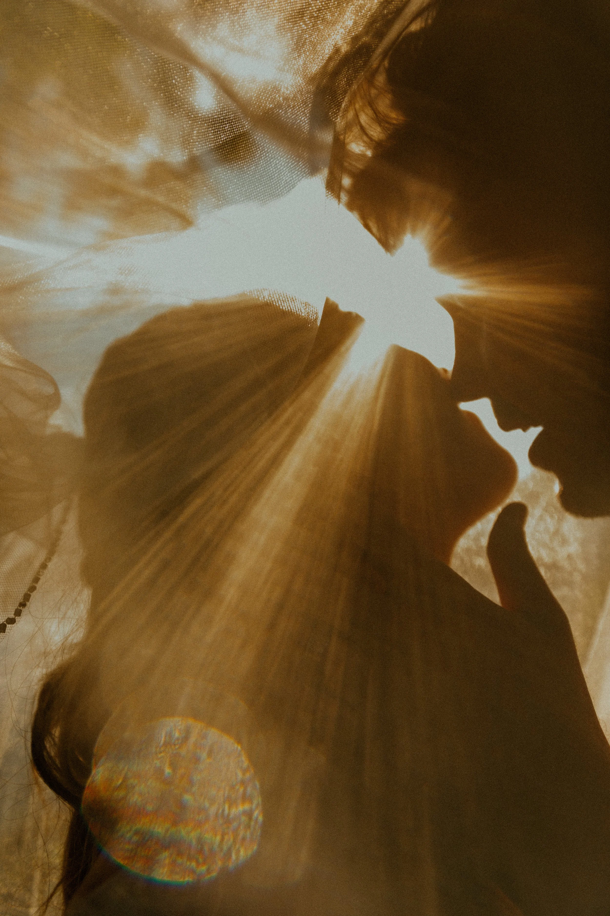 A close-up silhouette of a person's face with a textured, metallic, and abstract background with reflections and light flares.