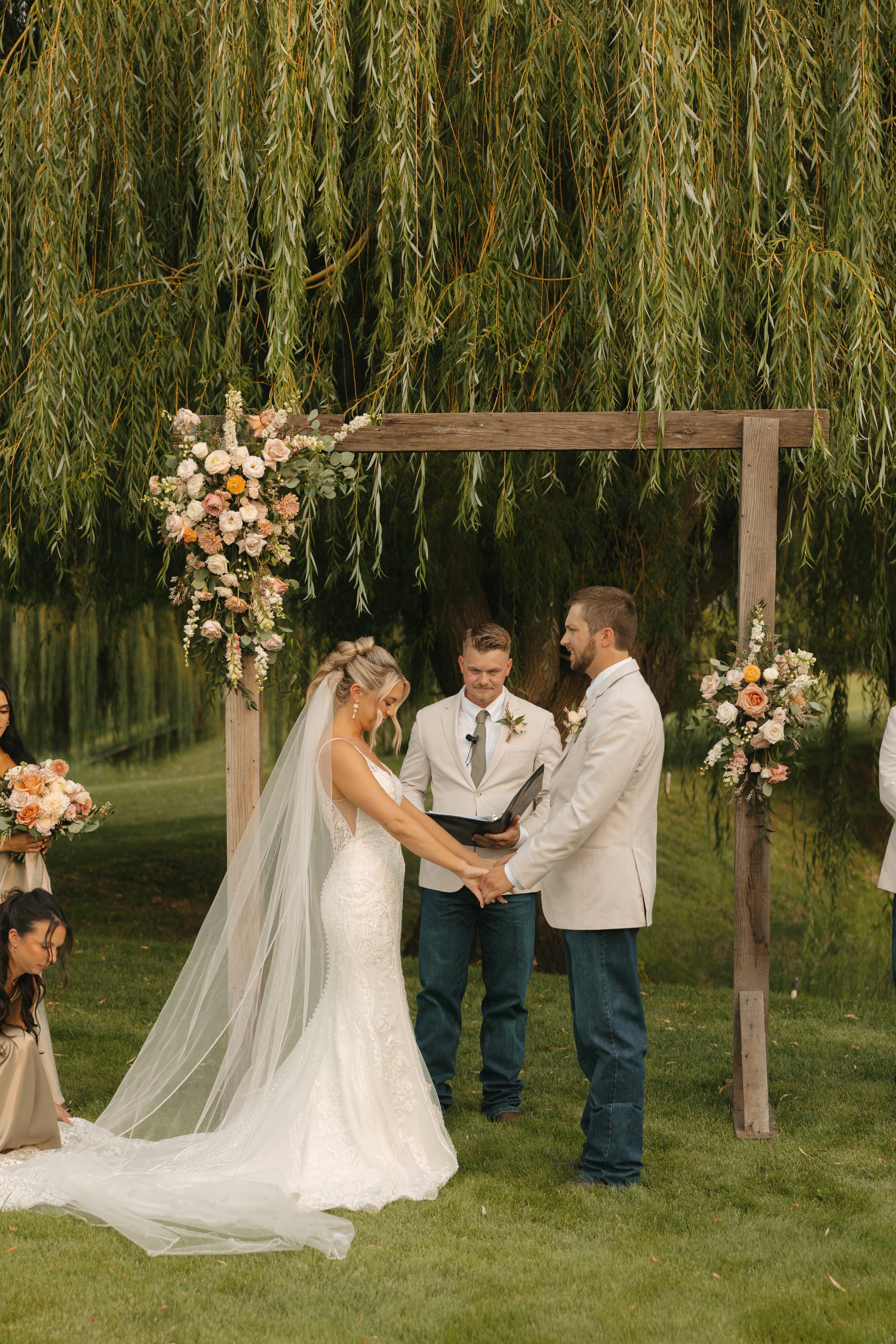 Soft blush, peach, and sage wedding with roses, poppy pods, calcynia, eucalyptus, ranunculus, dahlias at Gooseridge Winery Park Benton City WA Ceremony flowers
