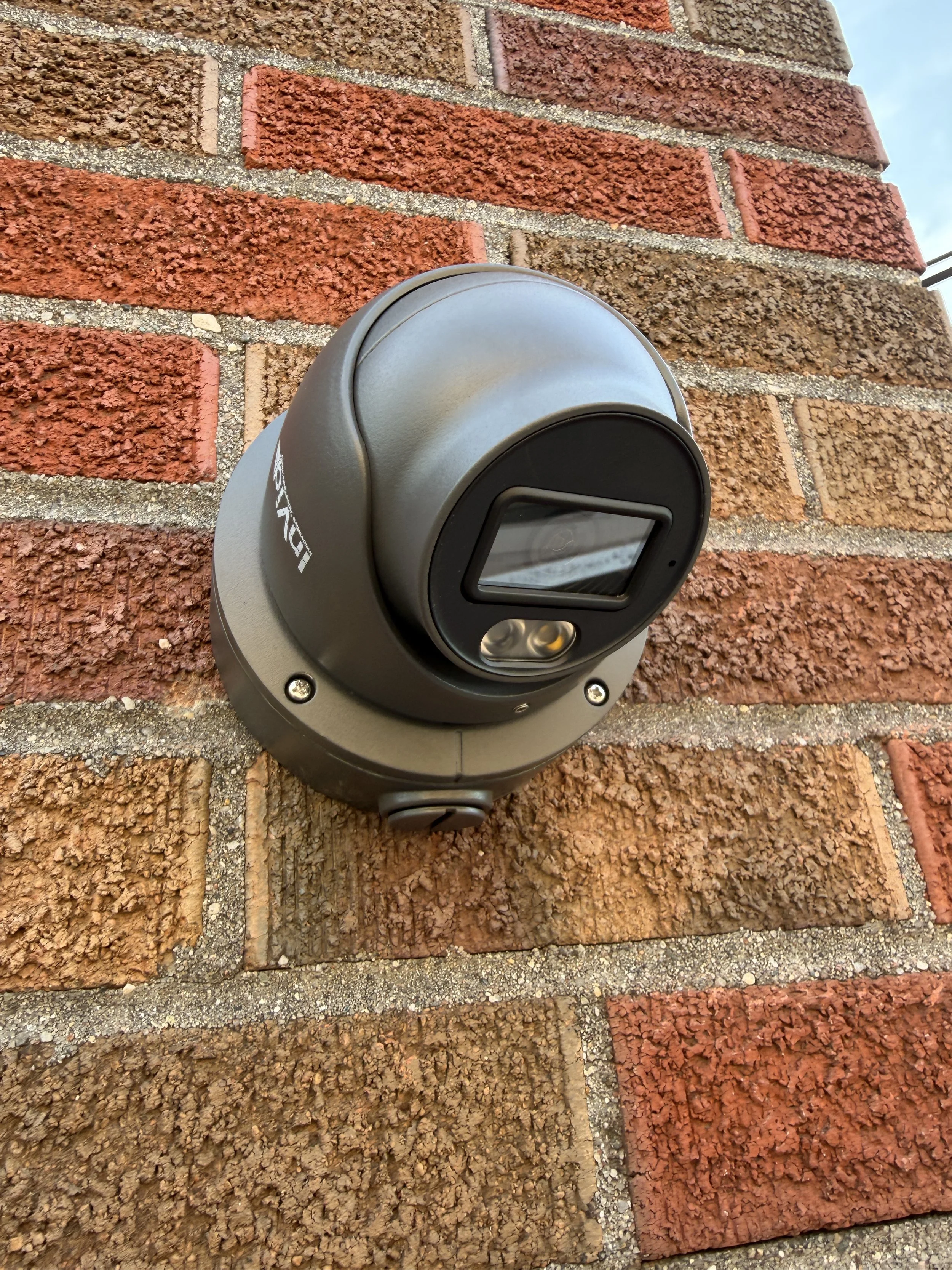 A security camera mounted on a brick wall