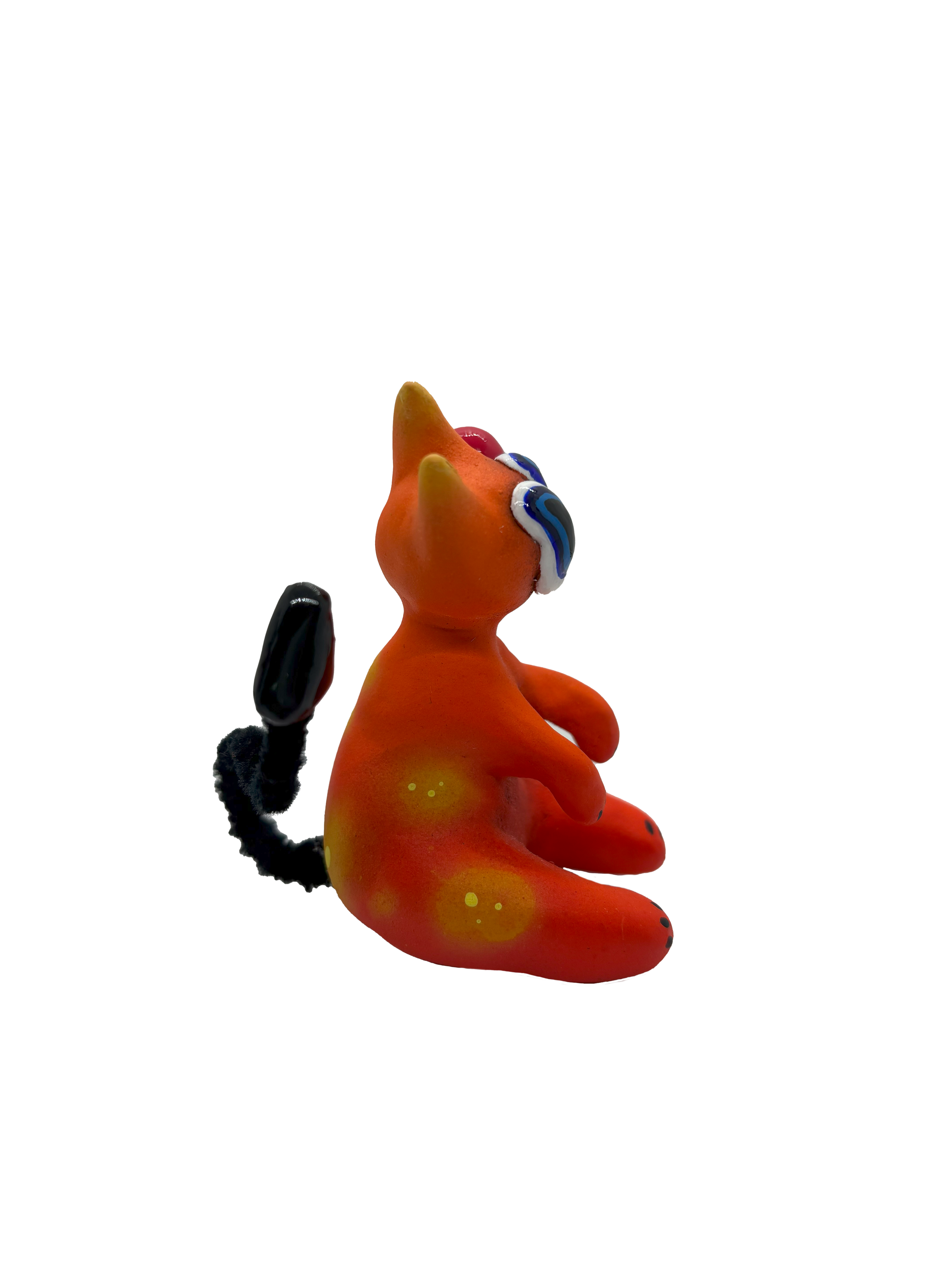 Colorful abstract sculpture resembling a stylized rabbit with a black tail and ears, made of vibrant orange, yellow, and black material.