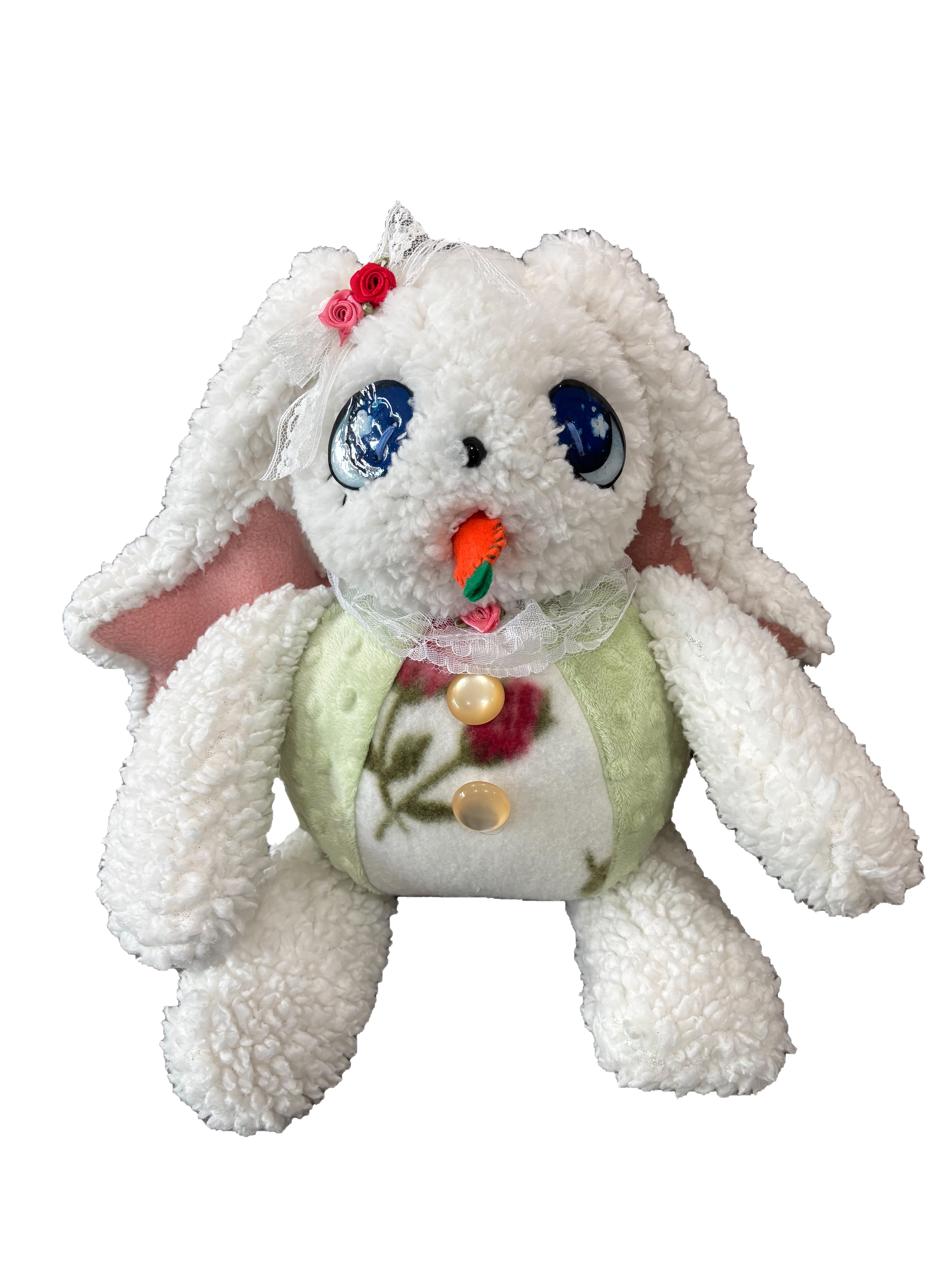 A plush stuffed animal resembling a white bunny with large blue eyes, pink inner ears, and an orange carrot nose. It wears a green vest with a floral pattern and has decorative pink and red roses with lace on its head.