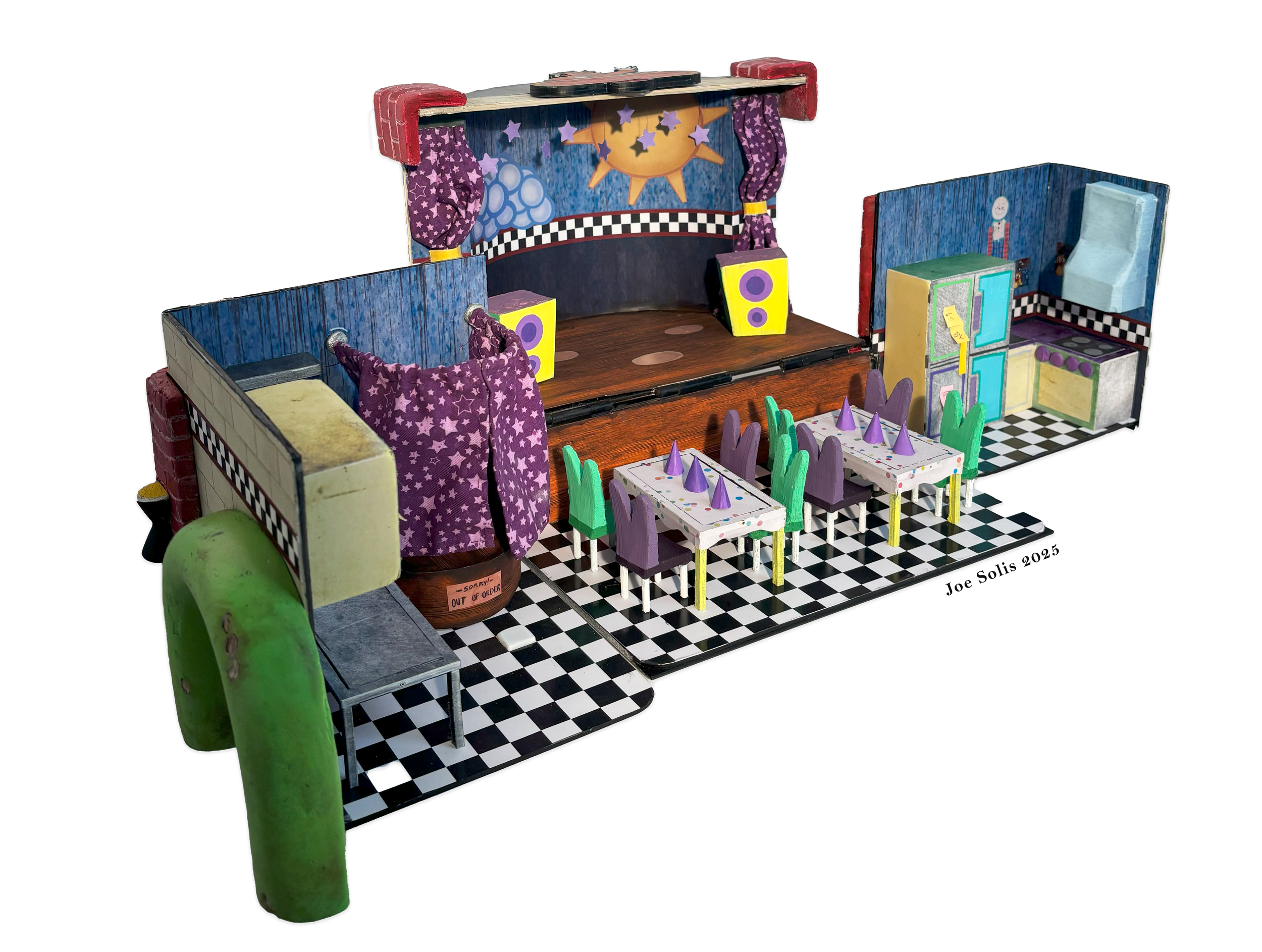 A miniature theatrical stage set with a colorful, whimsical design featuring a sun, stars, purple curtains, and checkered and black-and-white floors, with small chairs and a kitchen area.