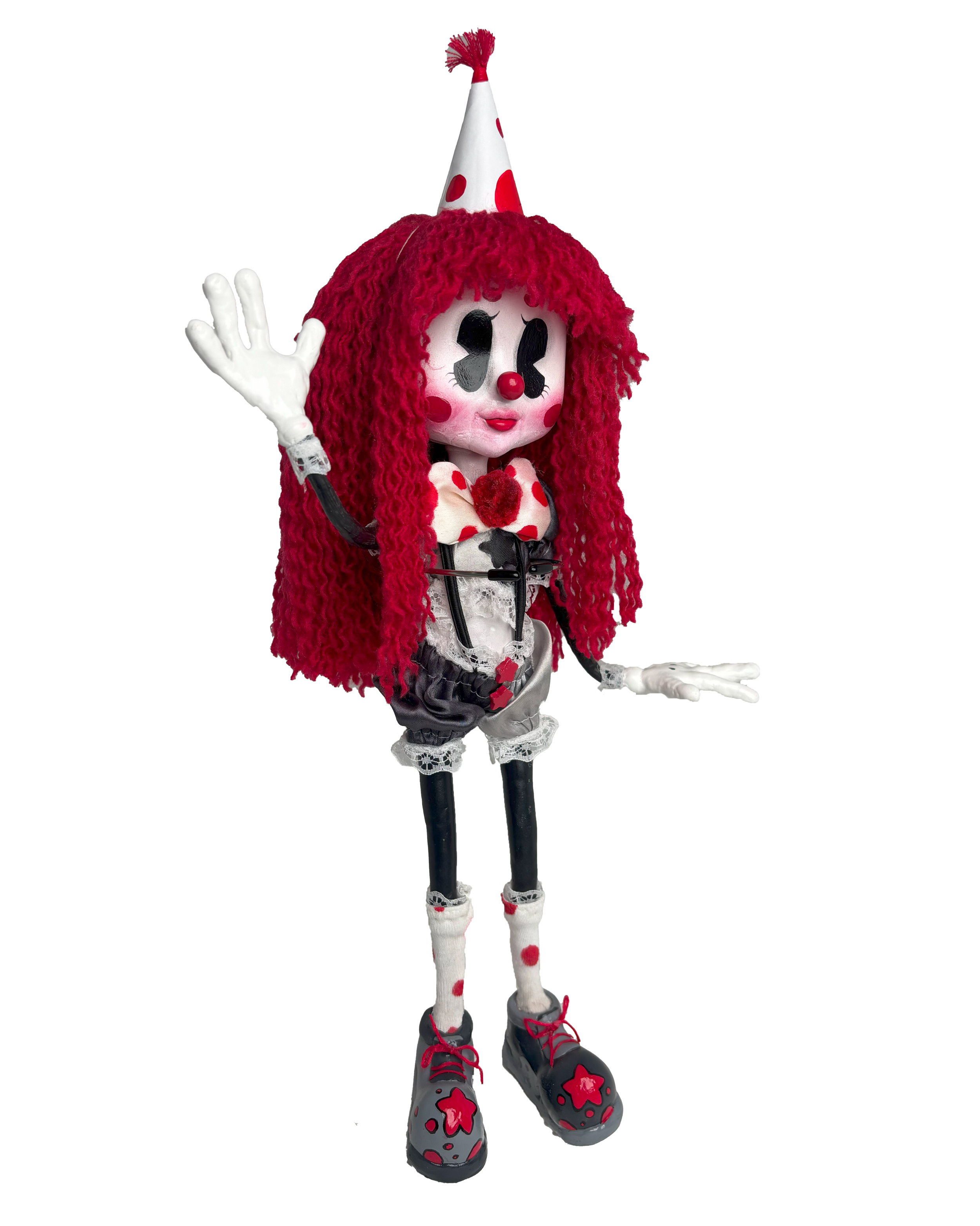 A person dressed in a clown costume with a red wig, painted face, and a polka-dotted hat, waving with their right hand. They wear a decorative outfit with red and black accents, polka-dot leggings, and shoes with red star patterns.