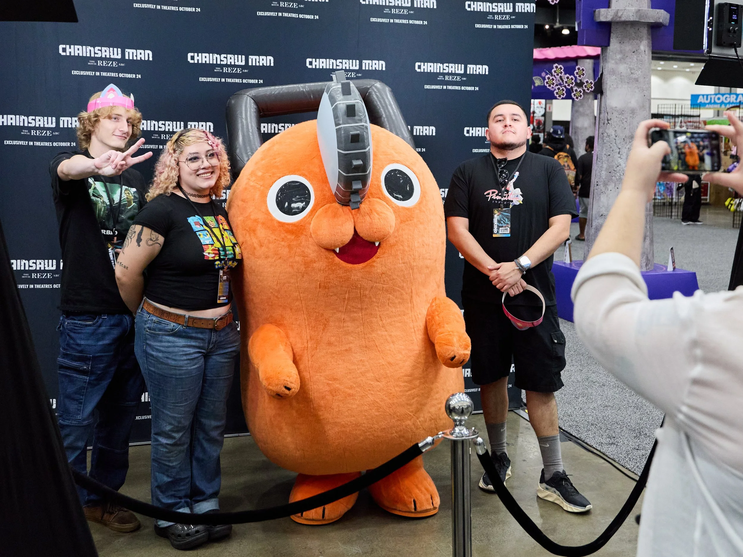 Person cosplaying as a character with a straw hat, red vest, and glasses, posing with fists up at a convention.