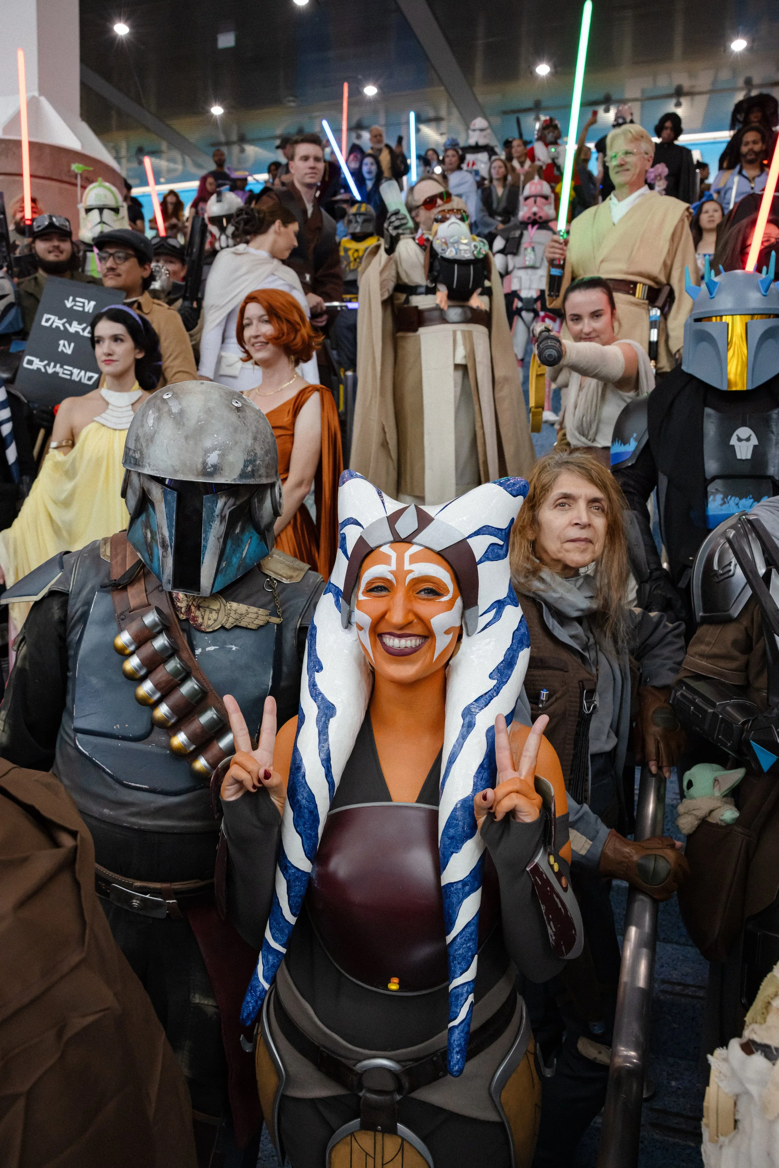 Group of people in superhero costumes at a comic convention, posing for a photo.