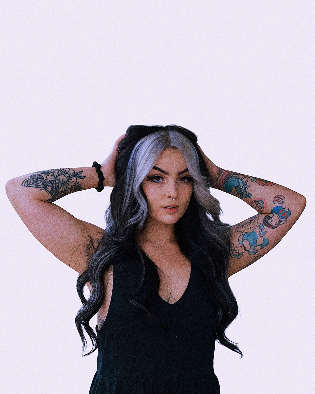 A woman with long black and gray hair. Platinum money-piece. Ghostface service. Platinum halo placement with black hair. High-contrast hair color.