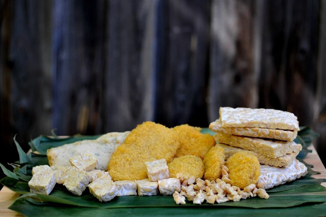 Assorted cheese and crackers on a green leaf-lined tray