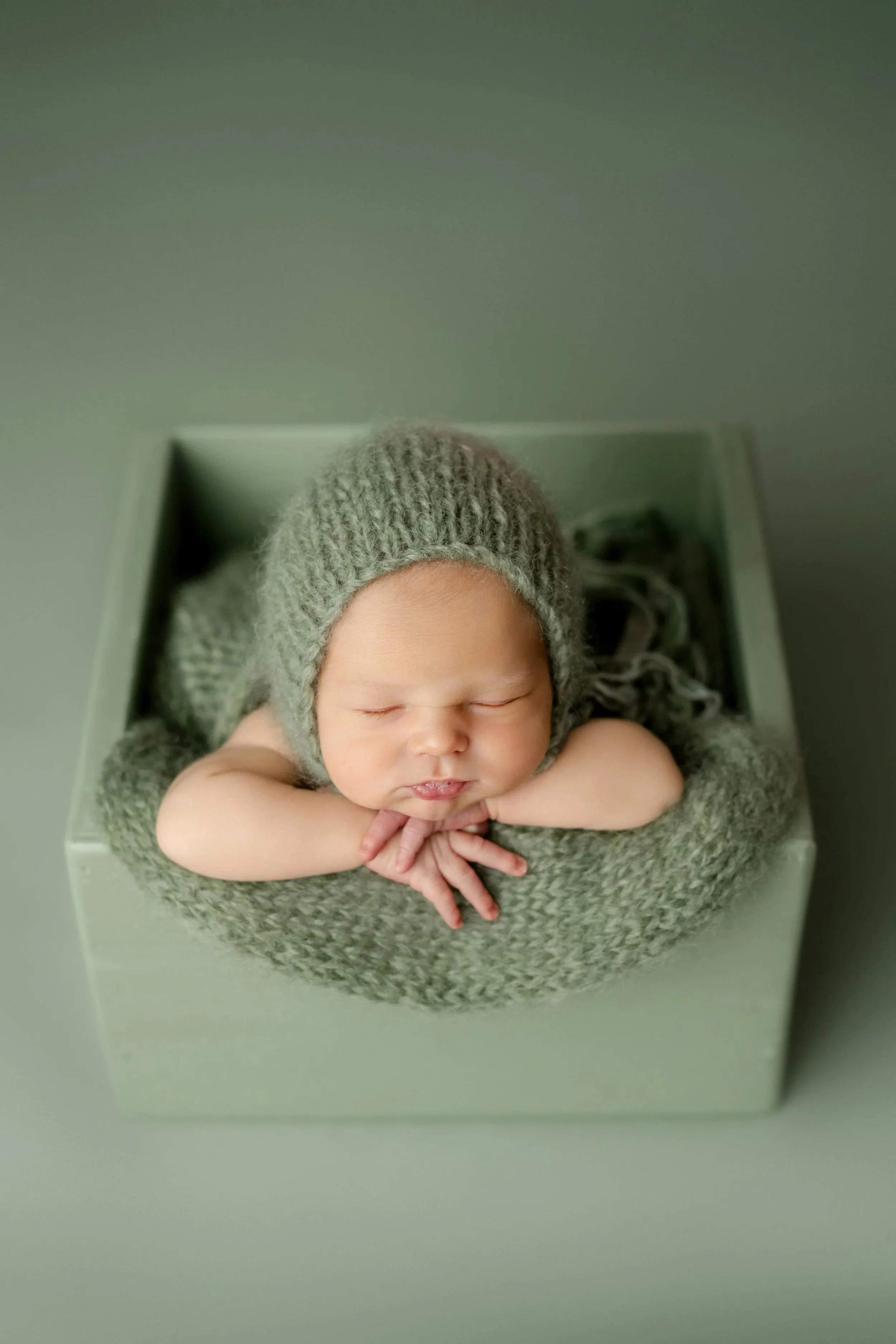 newborn baby on green photography studio springville alabama