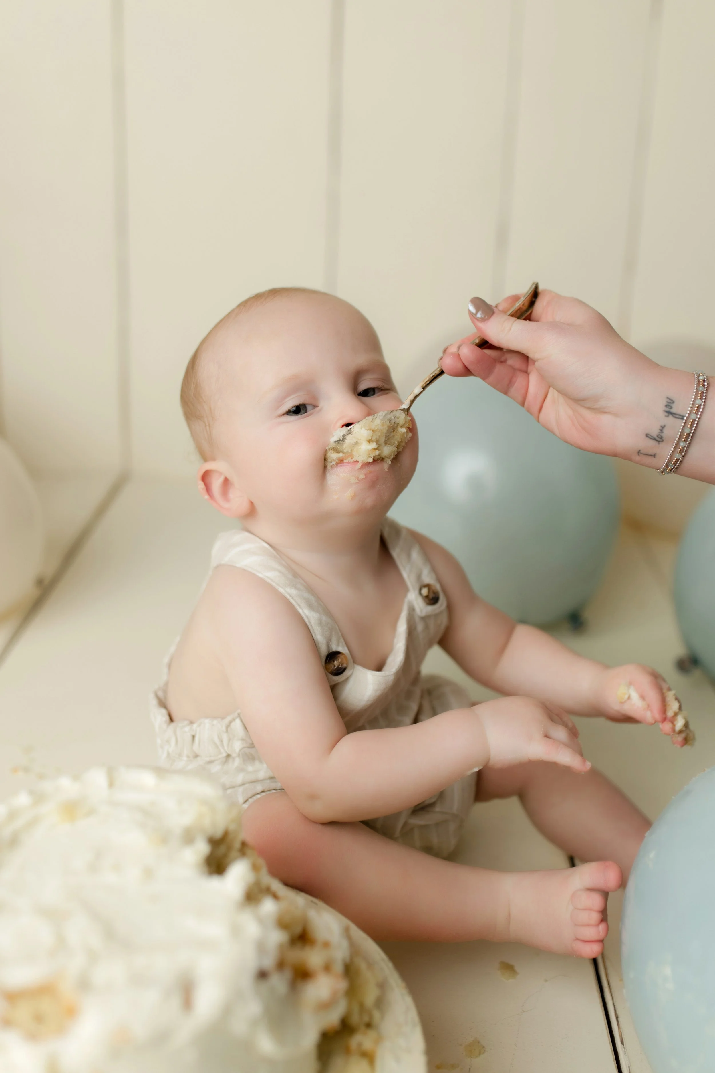 cake smash baby with mom feeding him with a spoon, funny cute photography 12 months birmingham al