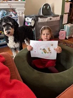 Child riding a carousel horse at an amusement park, with spectators watching.