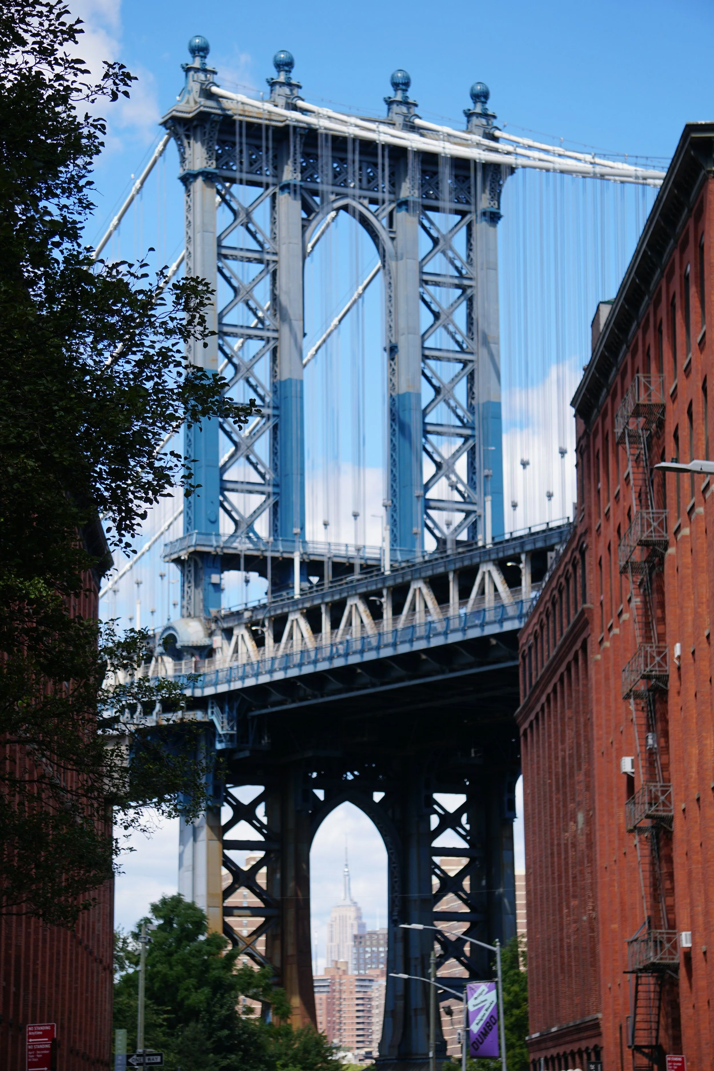 View of the Manhattan Bridge with the Empire State Building in the background in New York City.
