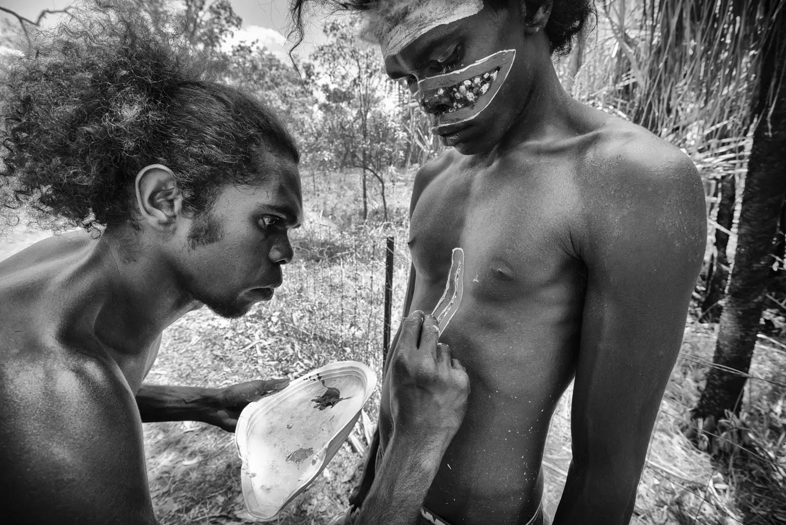 Jeremy-Wurrkunadj-Cameron-painting-his-brother-Miko-with-the-Sacred-totemic-Stringy-Bark-Tree-design.webp