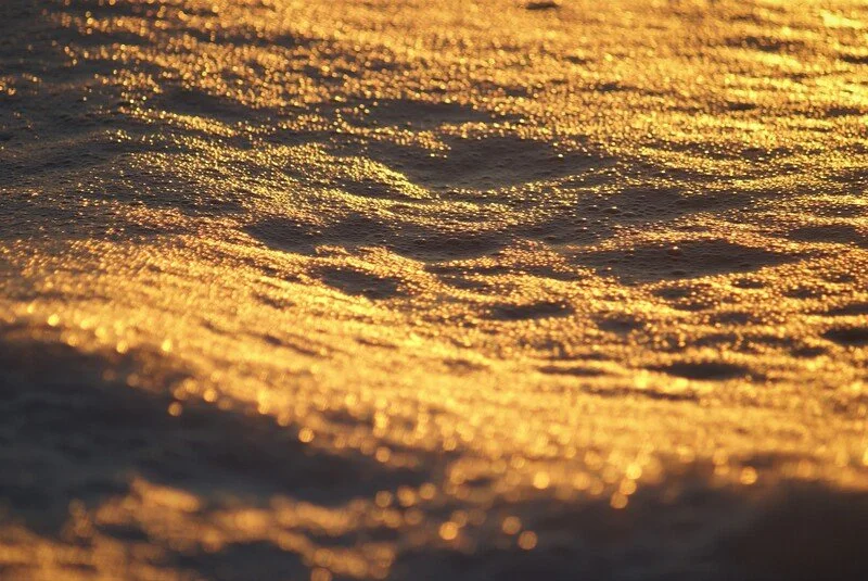 Sunlight reflecting off ocean waves during sunset.