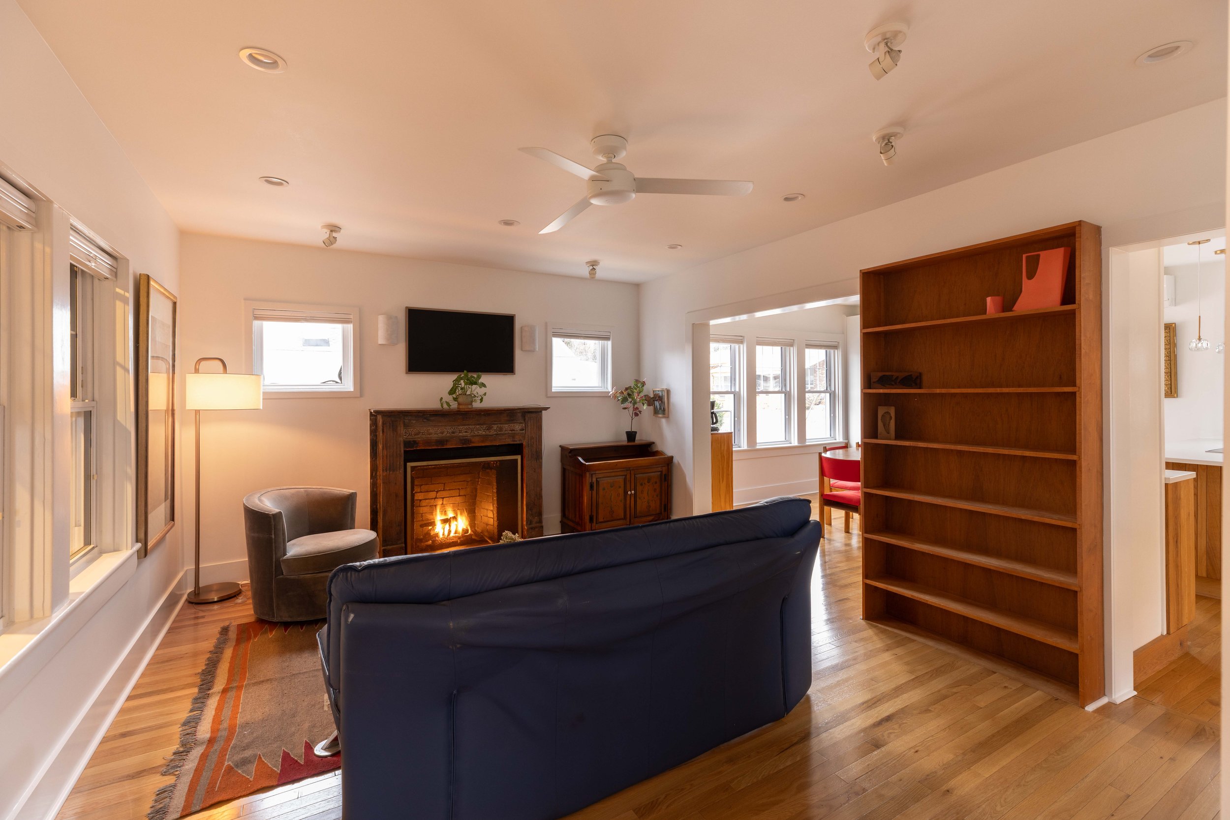 Living room with restored fireplace mantel — furnished Charlottesville City rental.

