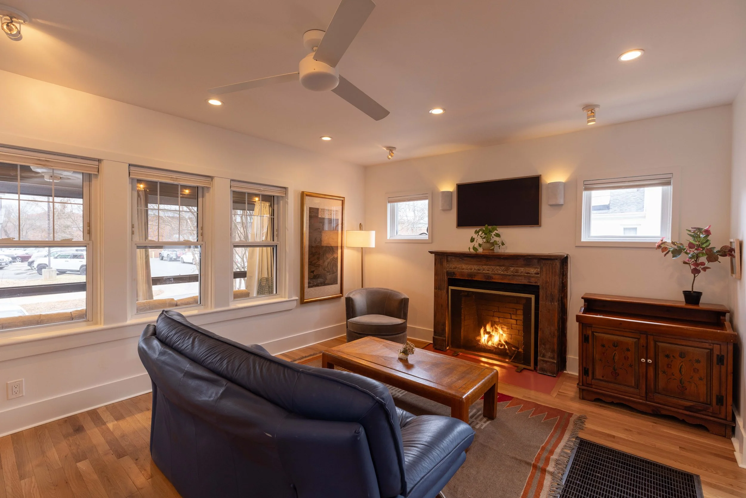 Living room with restored fireplace mantel — furnished Charlottesville City rental.