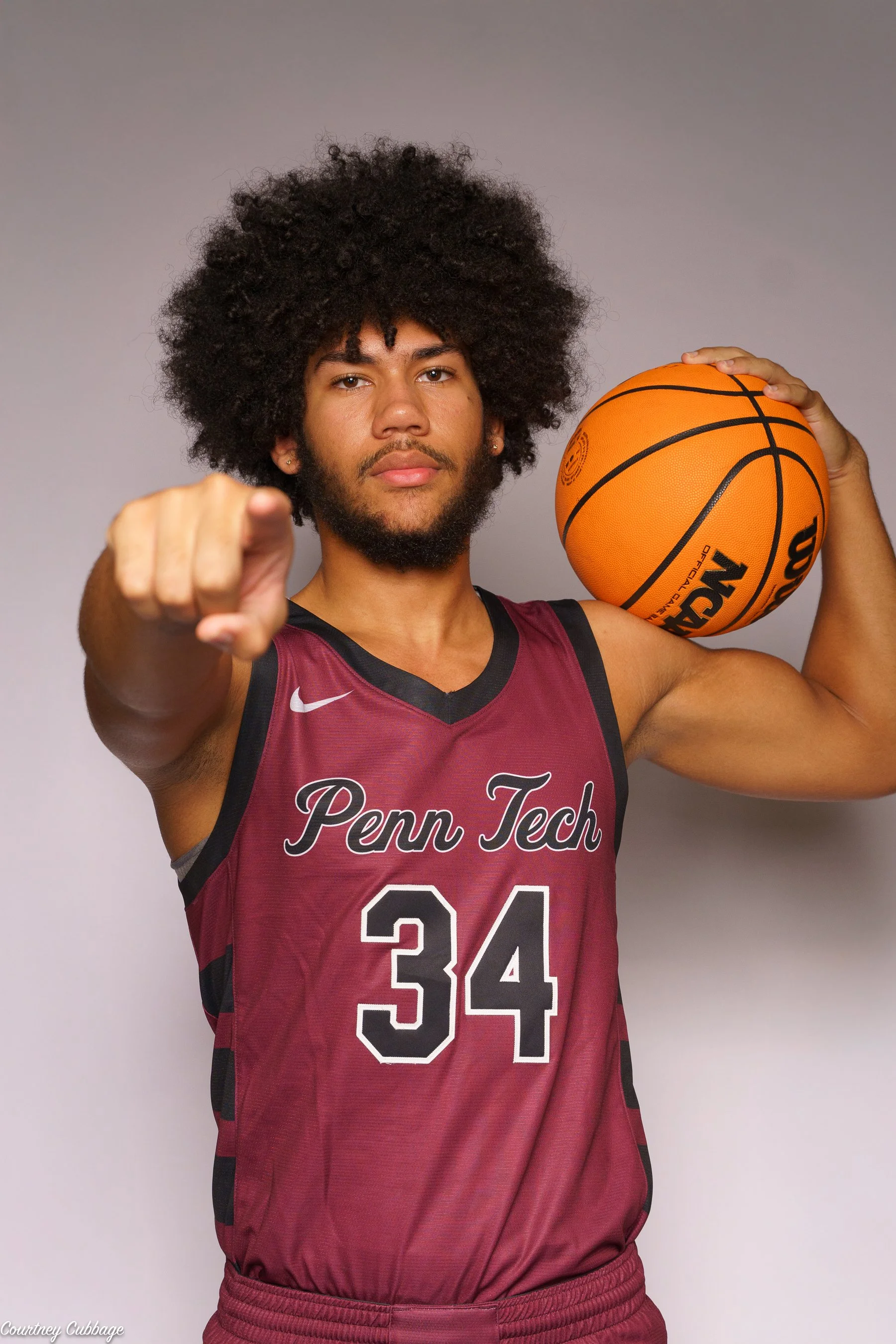Basketball player number 34 posing with a ball during a media day in South Jersey