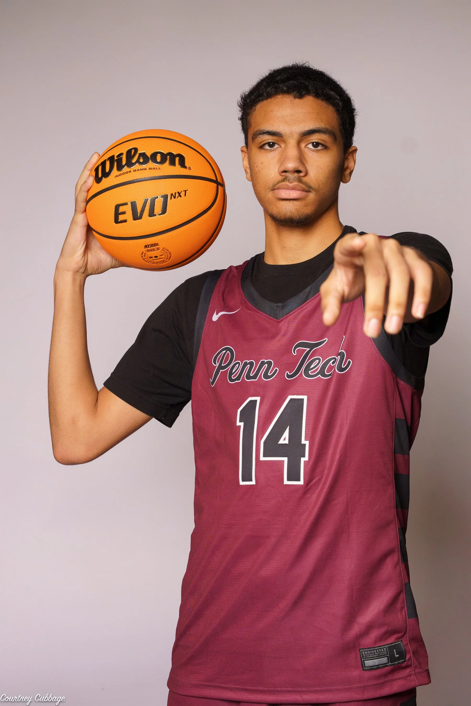 Basketball player number 14 posing with a ball during a media day in South Jersey