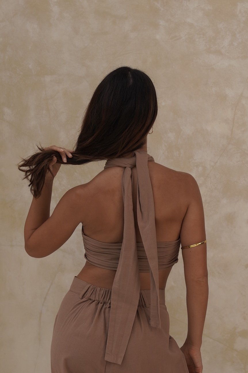 Close-up of Gaia Top styled wrapped from back, layered with spiritual jewellery in natural light
