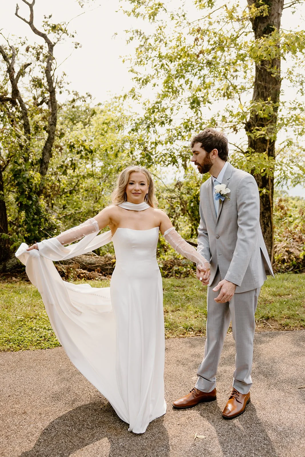 Bride twirling her wedding dress while the groom watches at Burritt on the Mountain