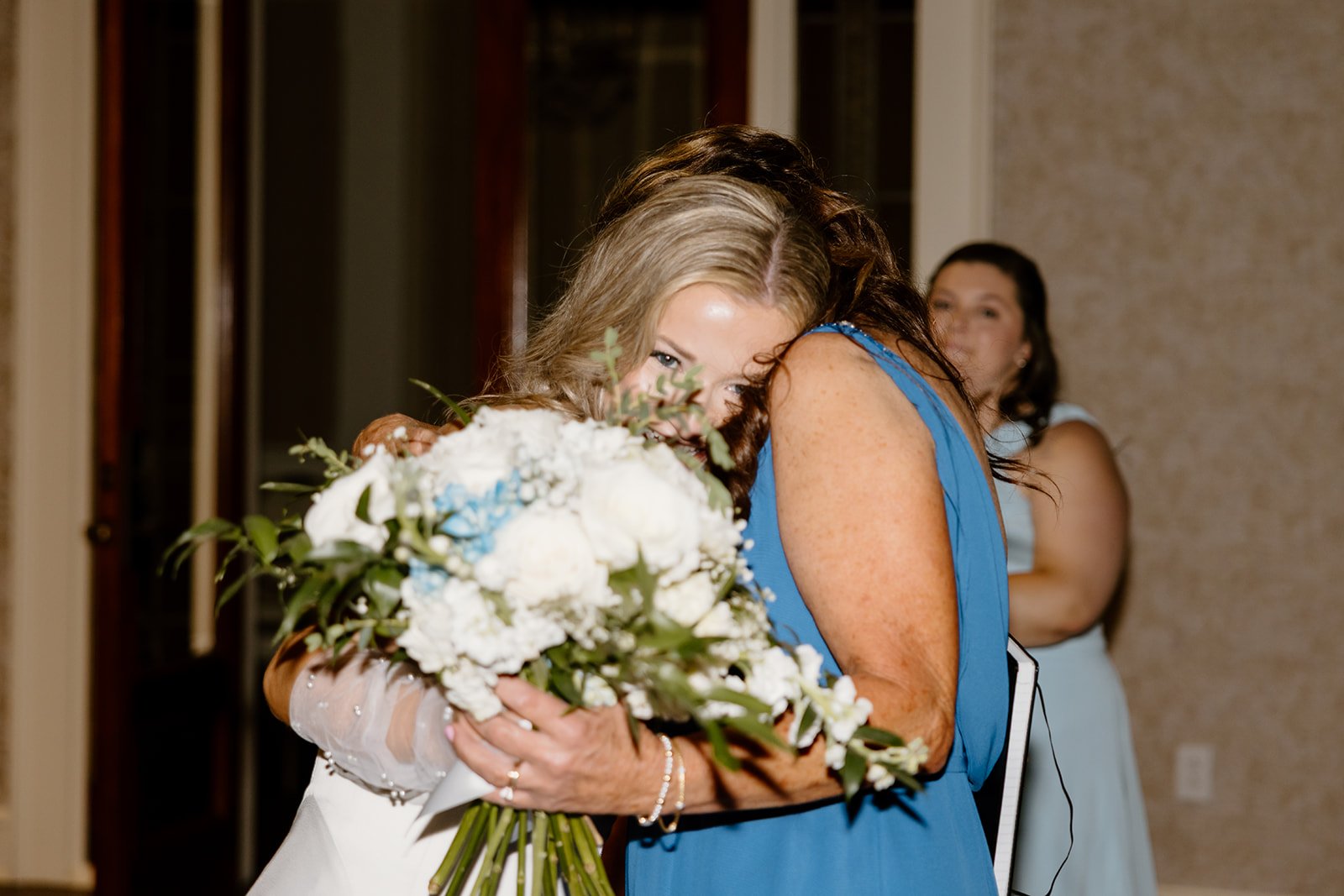 Bride sharing a hug after giving away her bouquet at Burritt on the Mountain