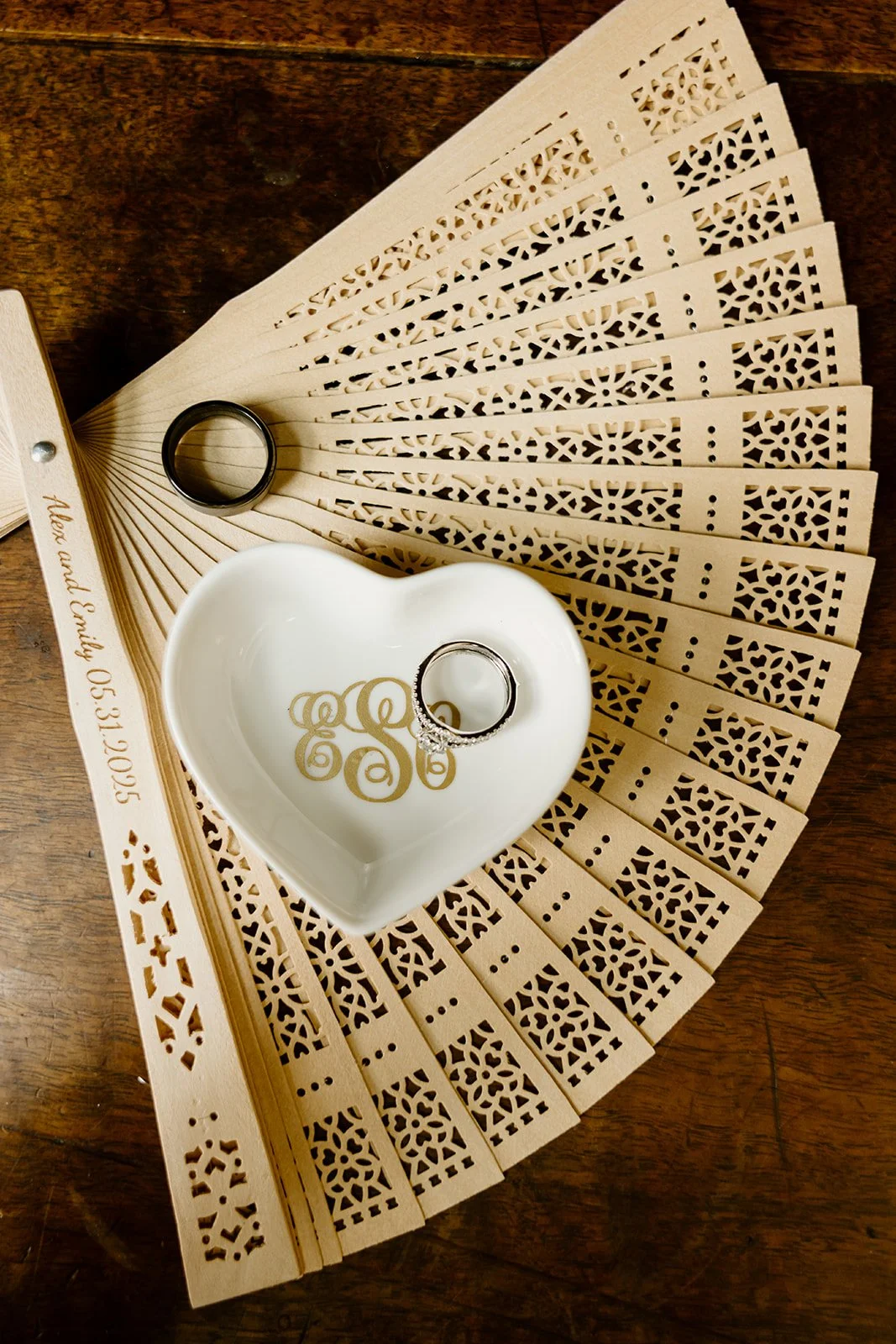 Wedding rings in a heart dish on a white fan