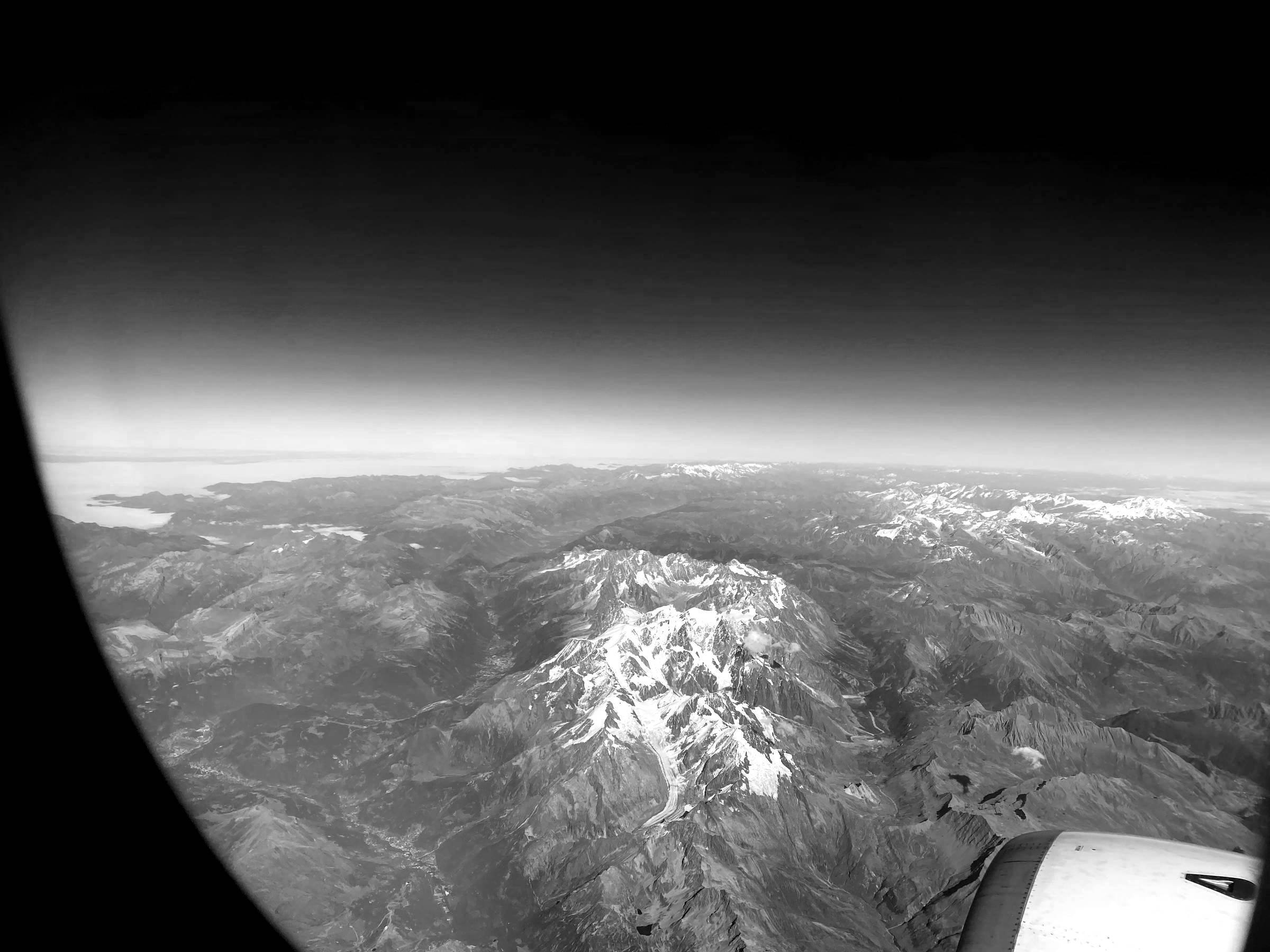 Blick aus dem Flugzeugfenster auf das Mont Blanc Massiv, schwarz-weiß.