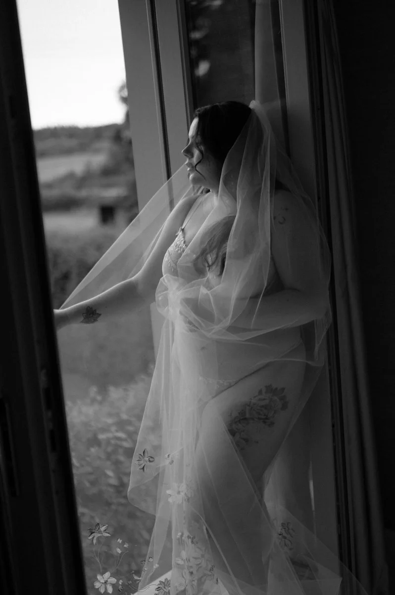 Bride standing in soft natural light during bridal boudoir session