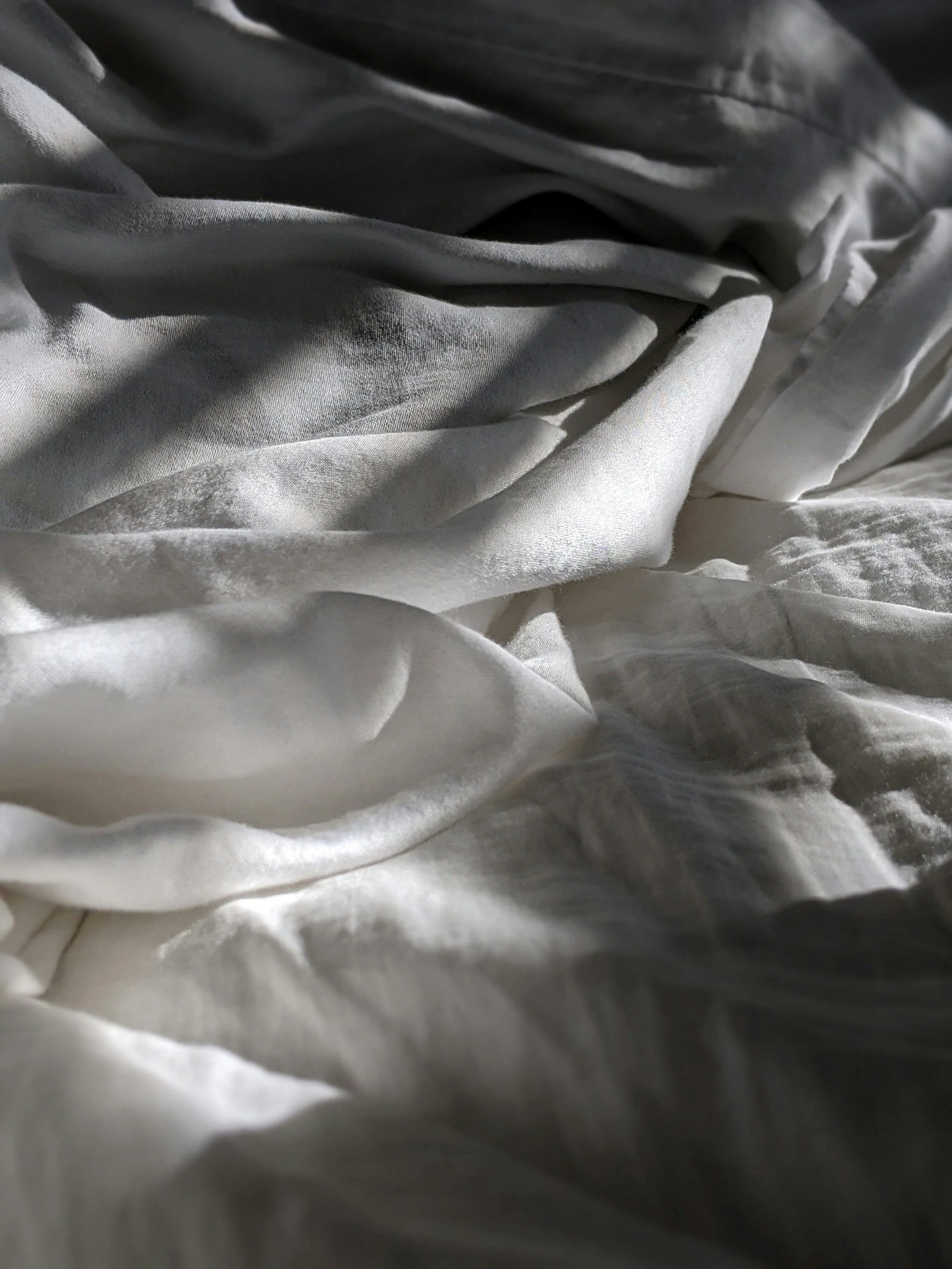 Close-up of white and gray fabric, crumpled and layered.
