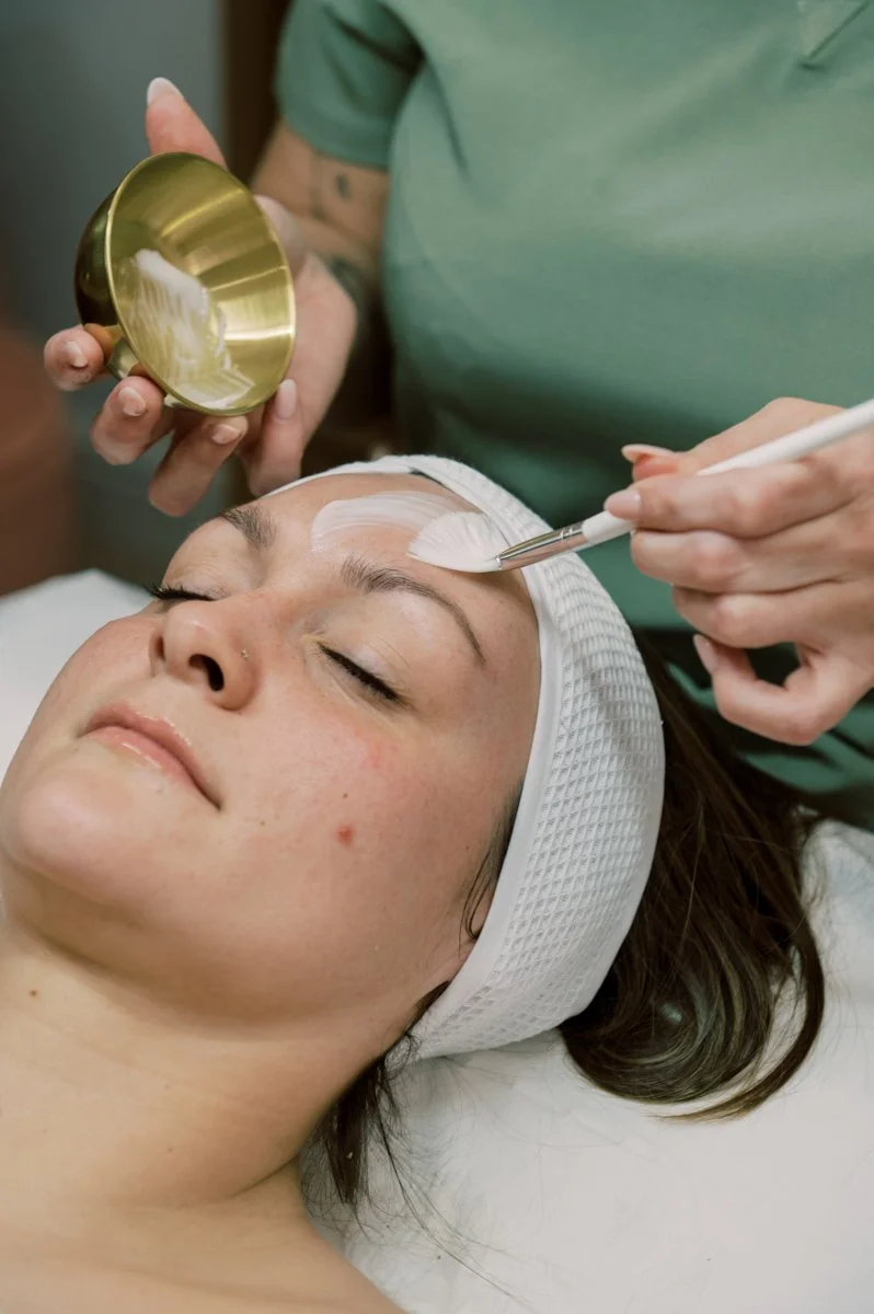 Beauty therapist applying a facial treatment during an editorial brand photography shoot