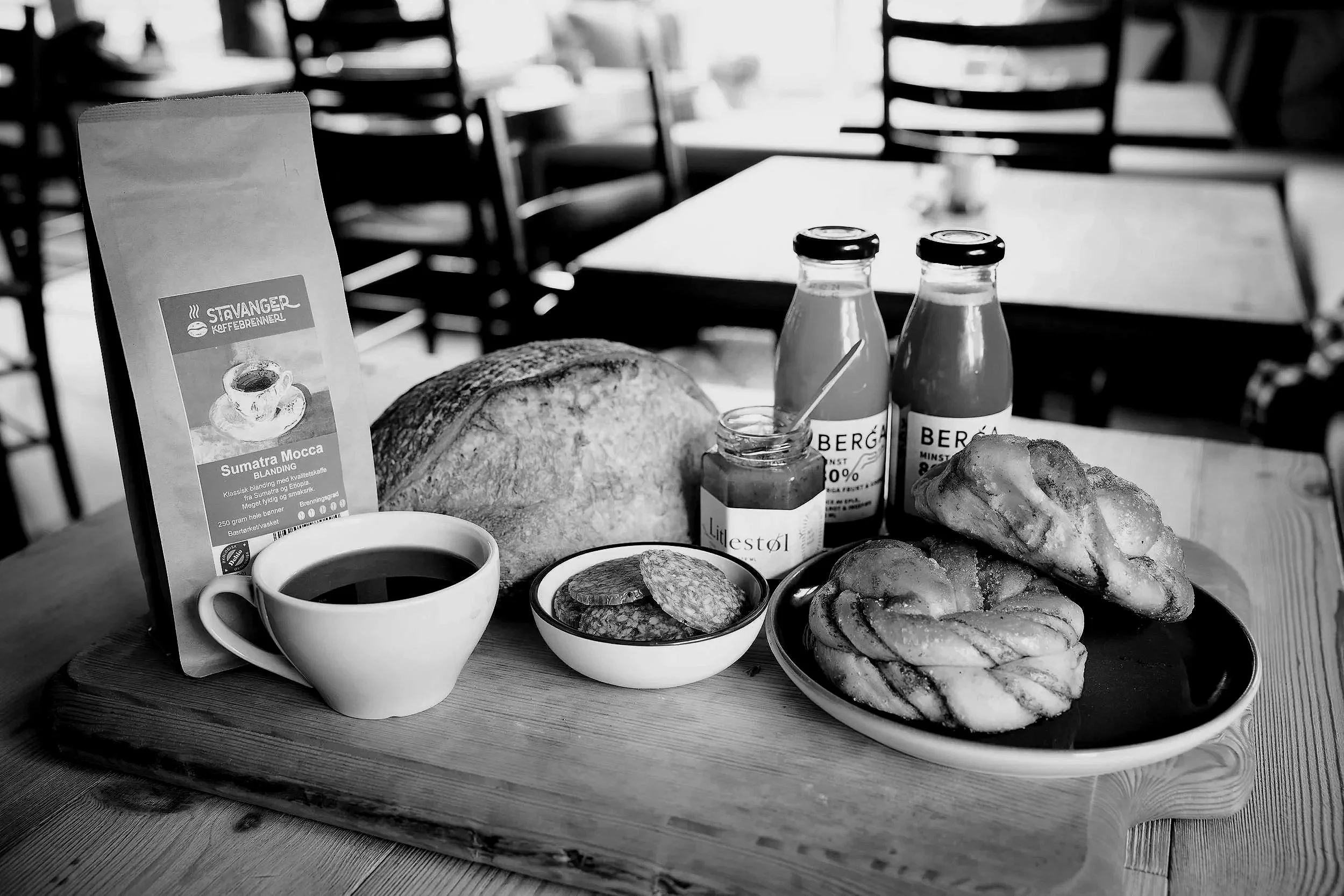Hekta Sirdal  Et bord med frokostmat, inkludert croissanter, brød, egg og drikker, på en restaurant eller kafé. Det er en meny om kaffe på bordet.