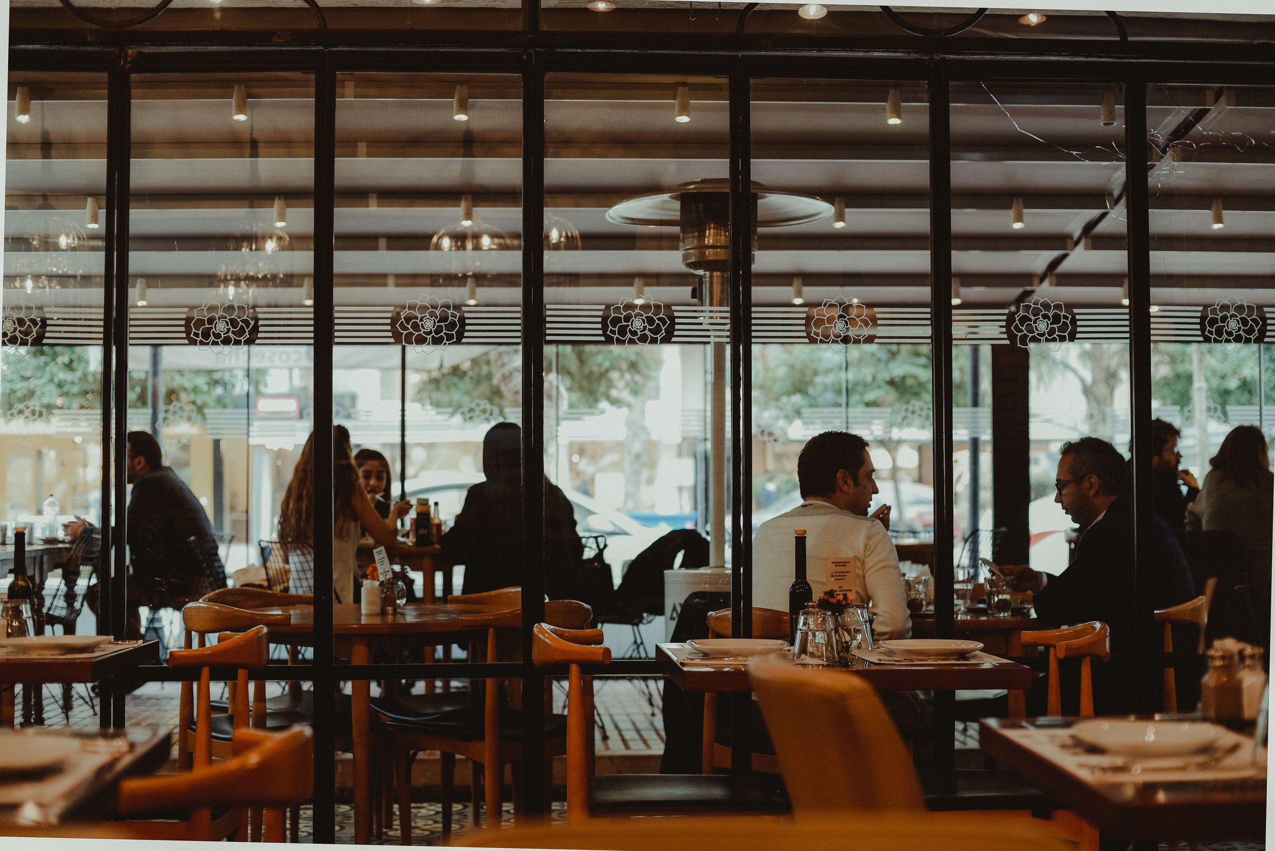 Restaurant scene with people eating at tables.