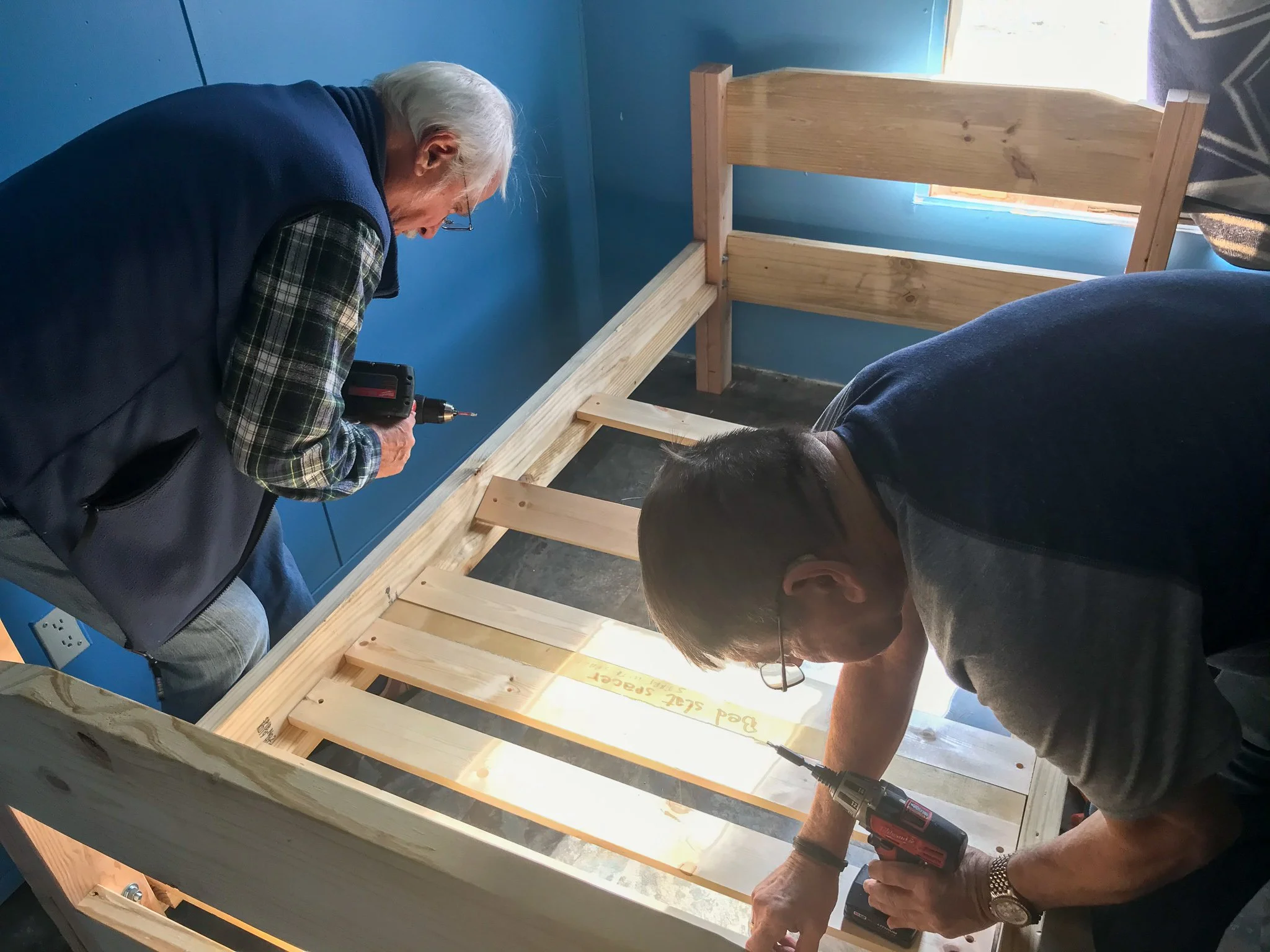 Don and John installing a bed for a child.