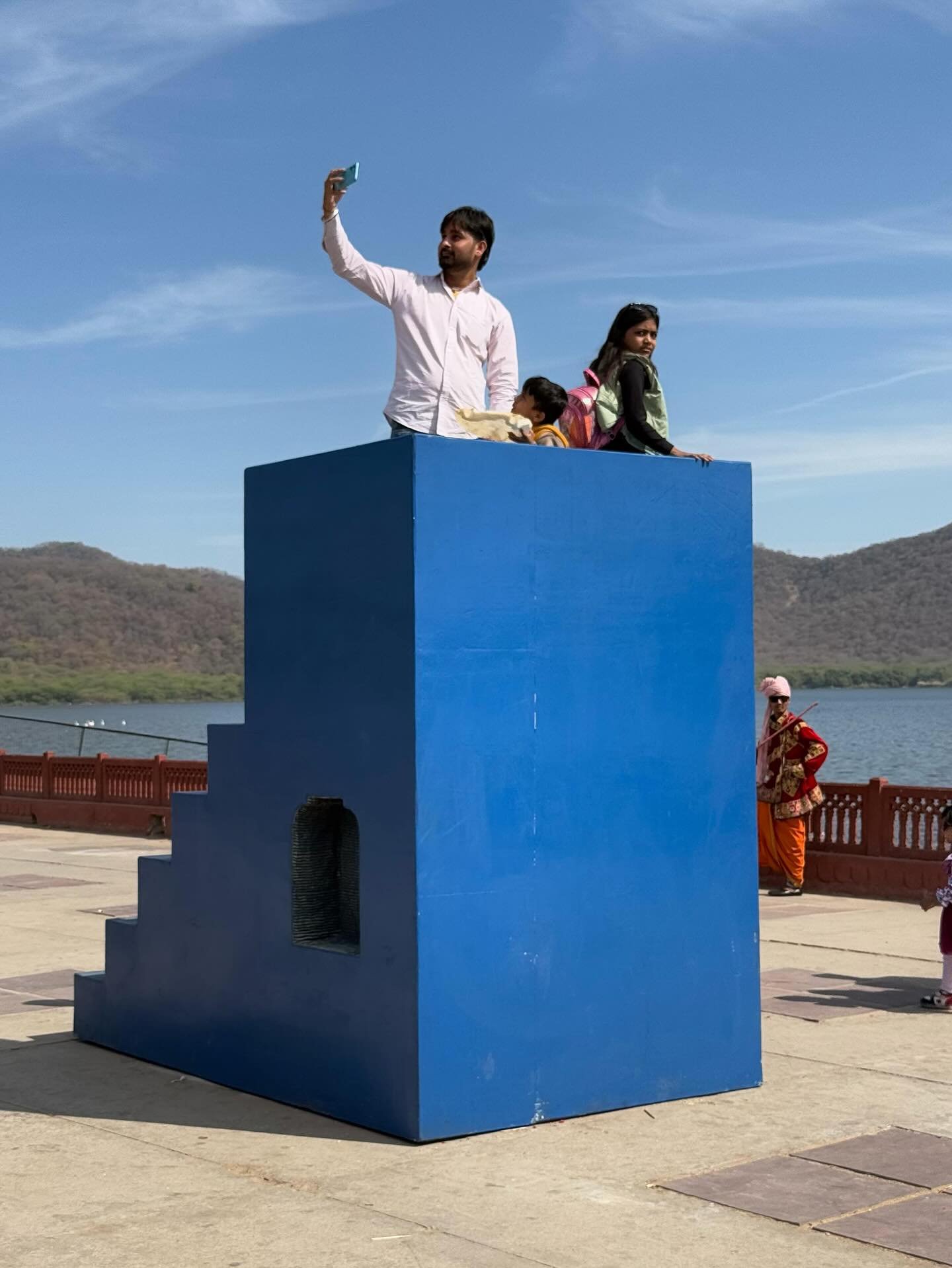 Seeds of Yesterday / Tomorrow
by Social Design Collaborative
📍Jal Mahal, Jaipur Art Week 4.0

Towering in a field of open sky, this indigo fragment of rural architecture invites not just observation &mdash; but interaction. A father lifts his phone 