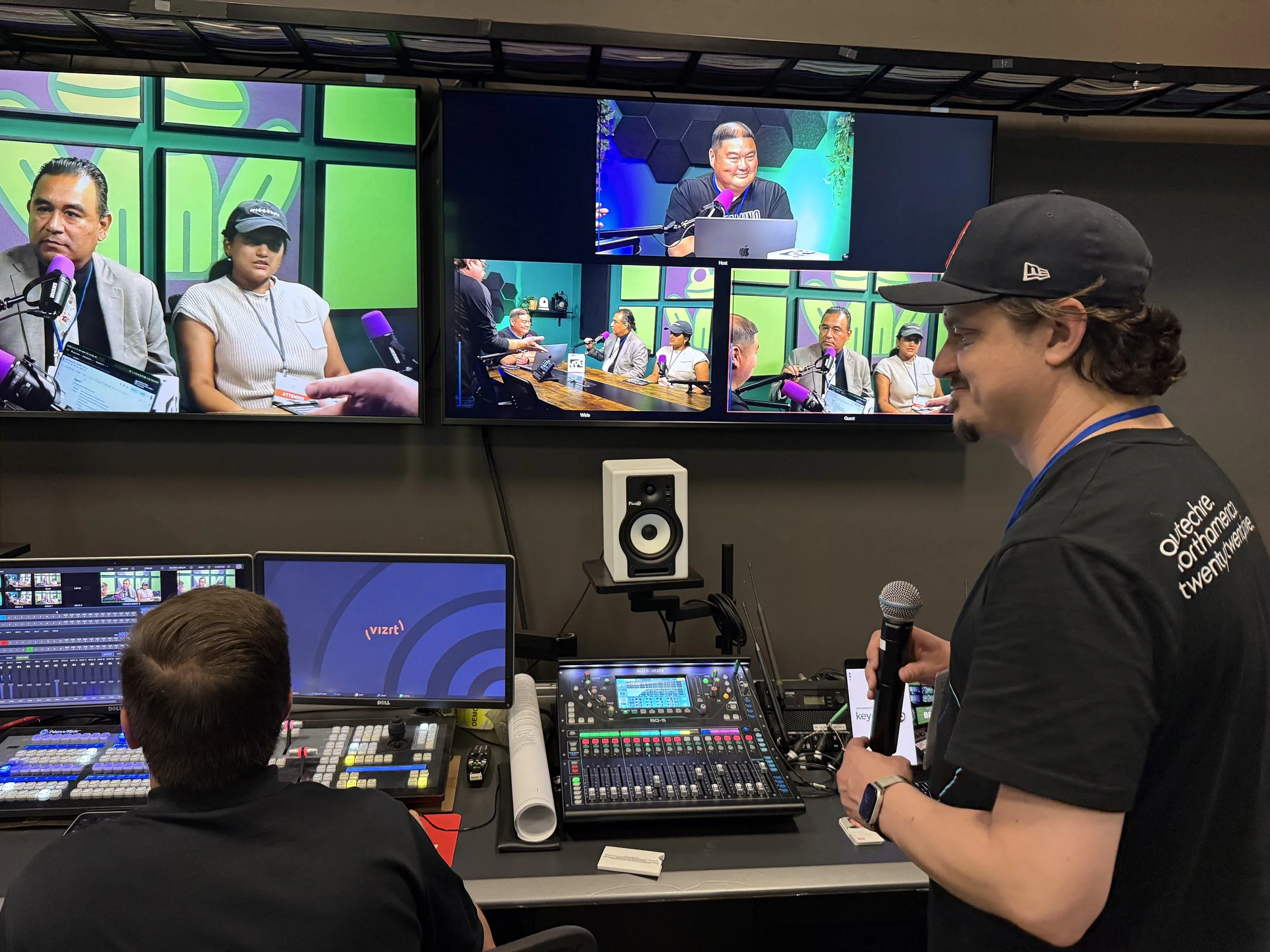 A teacher wearing a headset relays cues between the podcast studio and the control room at Key Code Media
