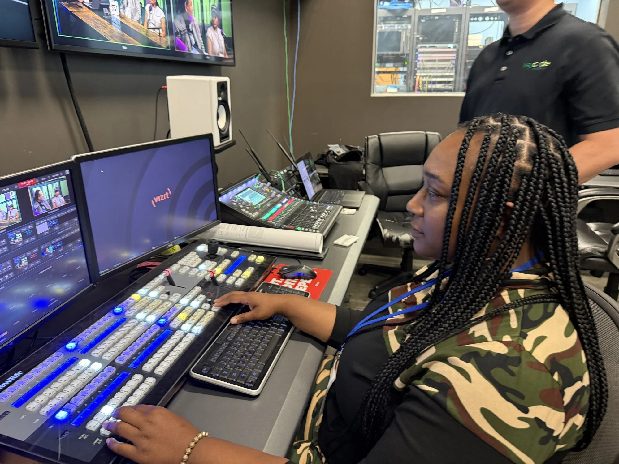 A teacher at the Vizrt TriCaster in the Key Code Media control room, ready to record the podcast episode