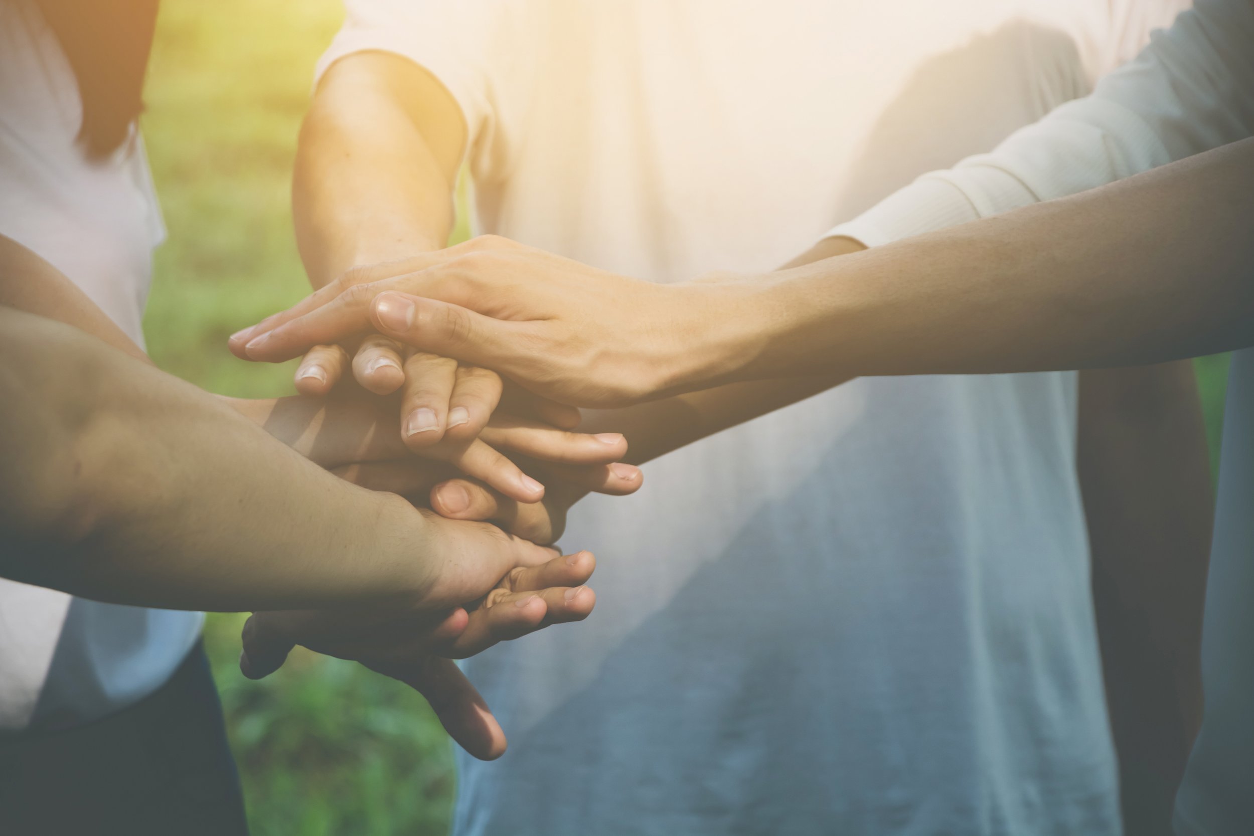 Three people joining hands in solidarity and support