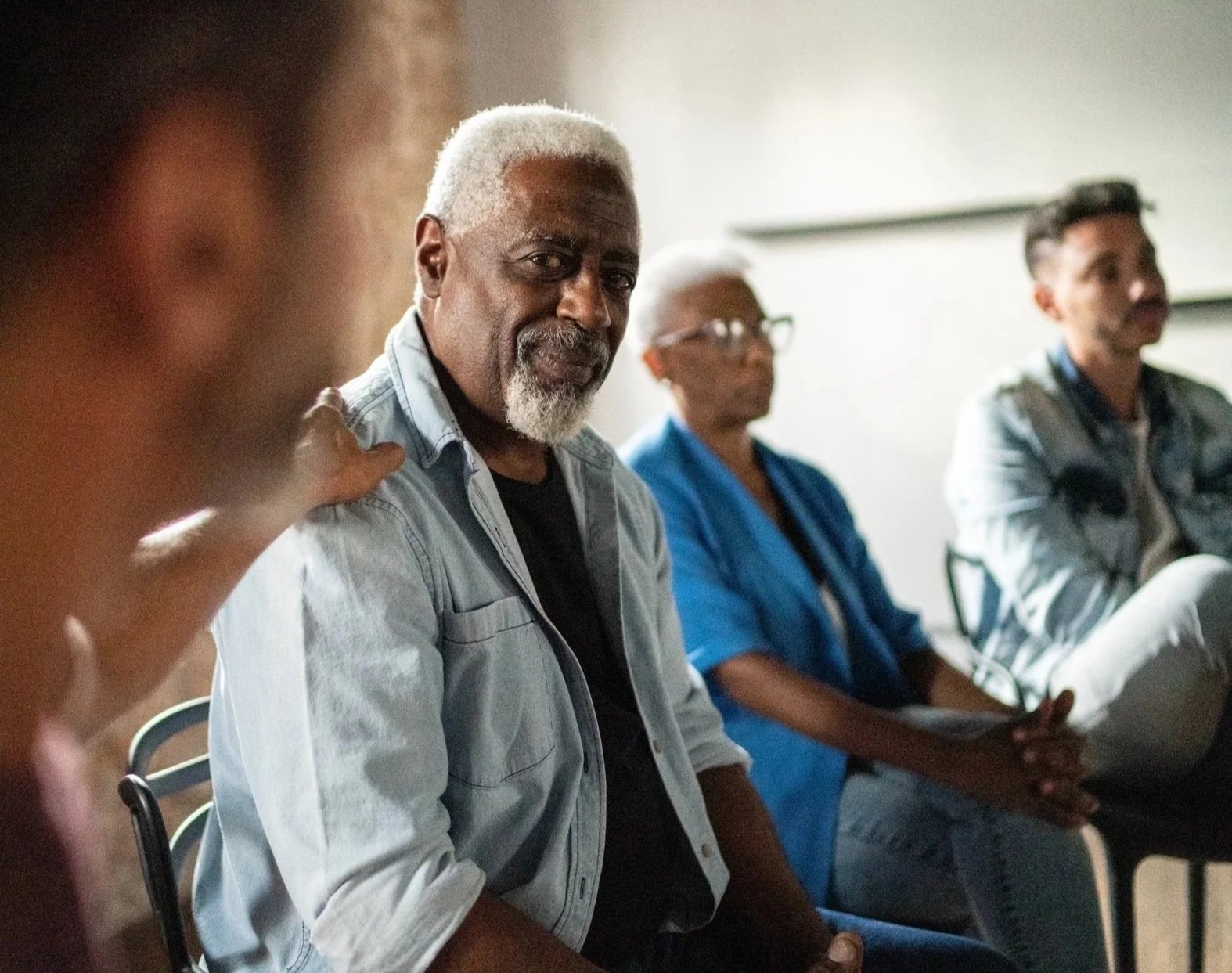 Older gentleman being supported during a group meeting