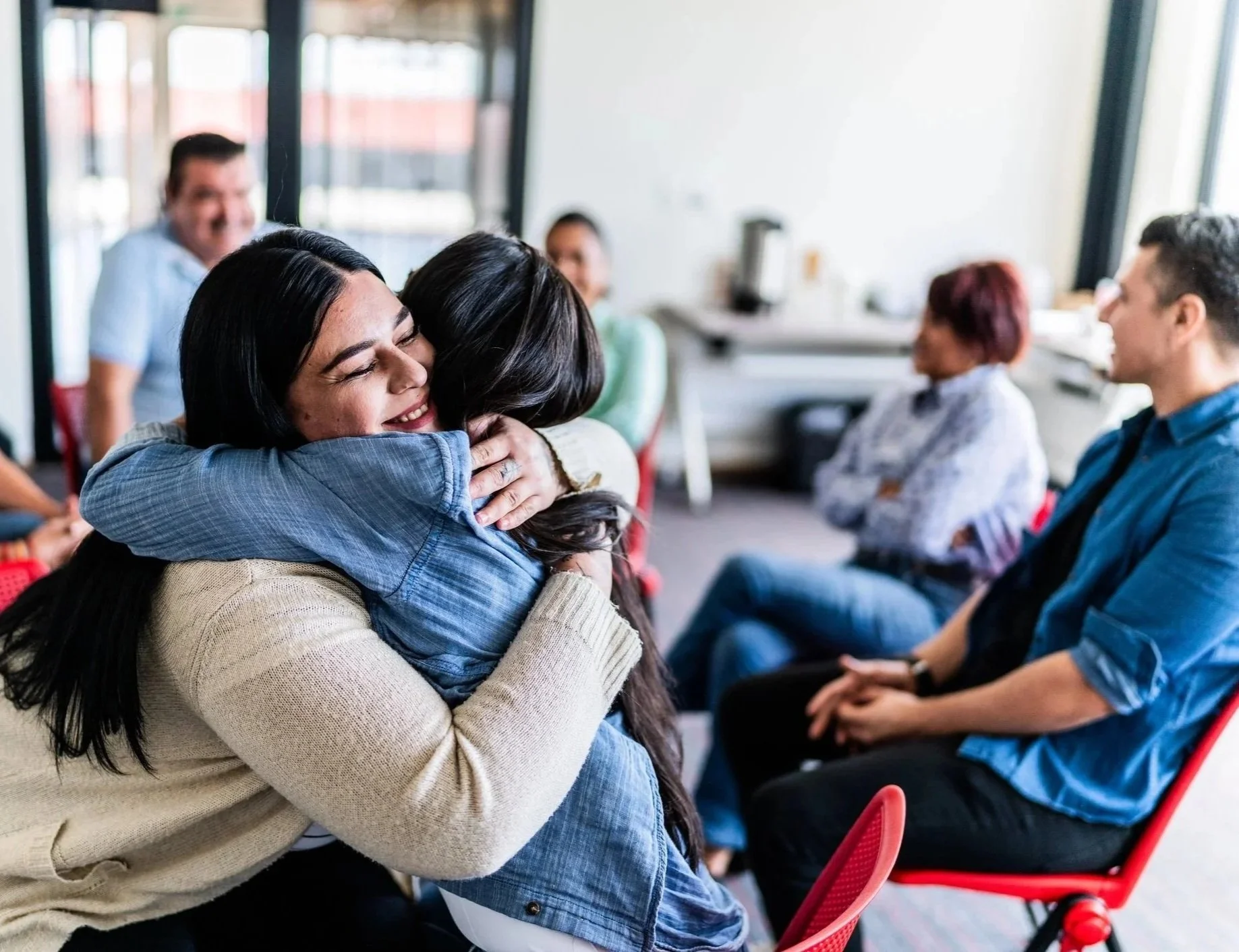 two women hugging at group event