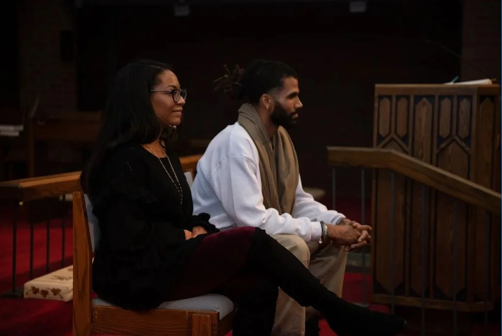 A male and female sit listening at the Q&A for the documentary "This is [Not] Who We Are"