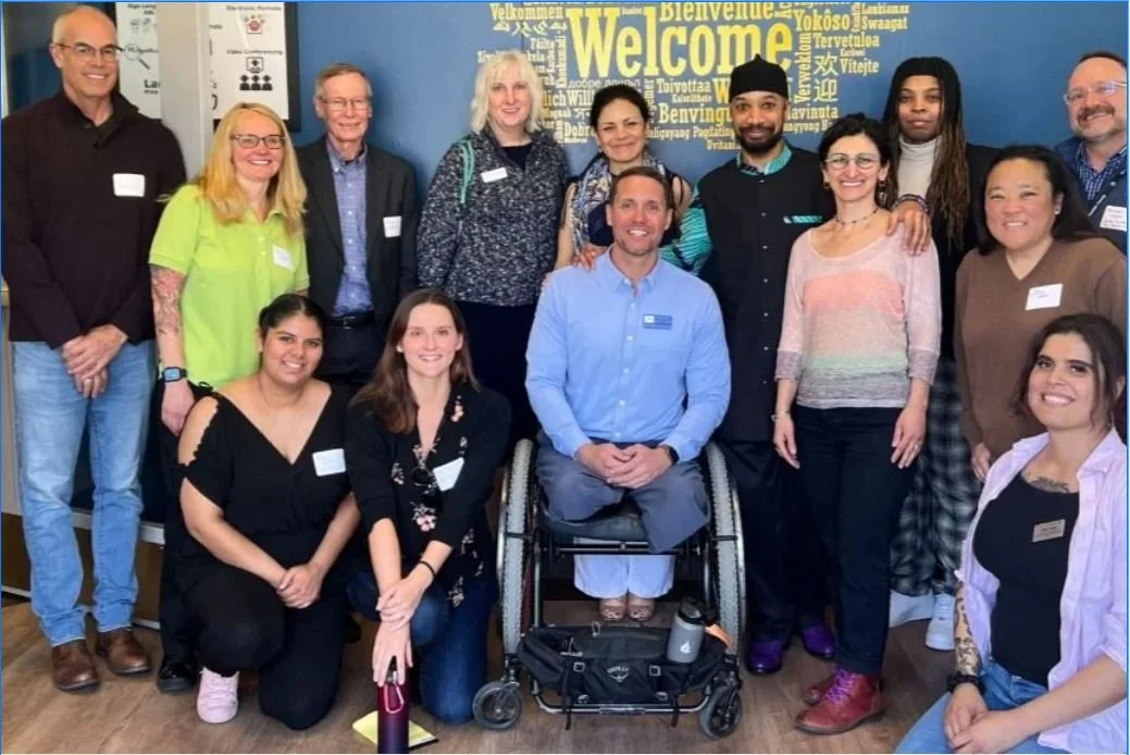 A group of smiling people pose at a 2023 DEIA collaborative luncheon in Boulder
