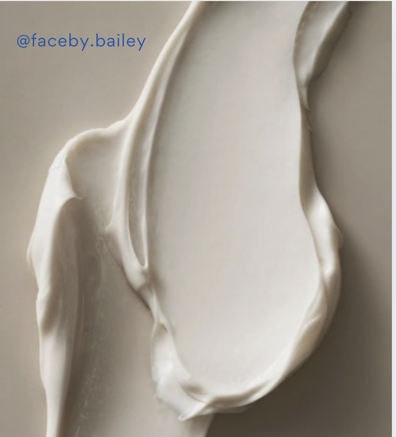 Close-up of a creamy white substance, possibly a dollop of whipped cream or a similar soft food on a light-colored surface.