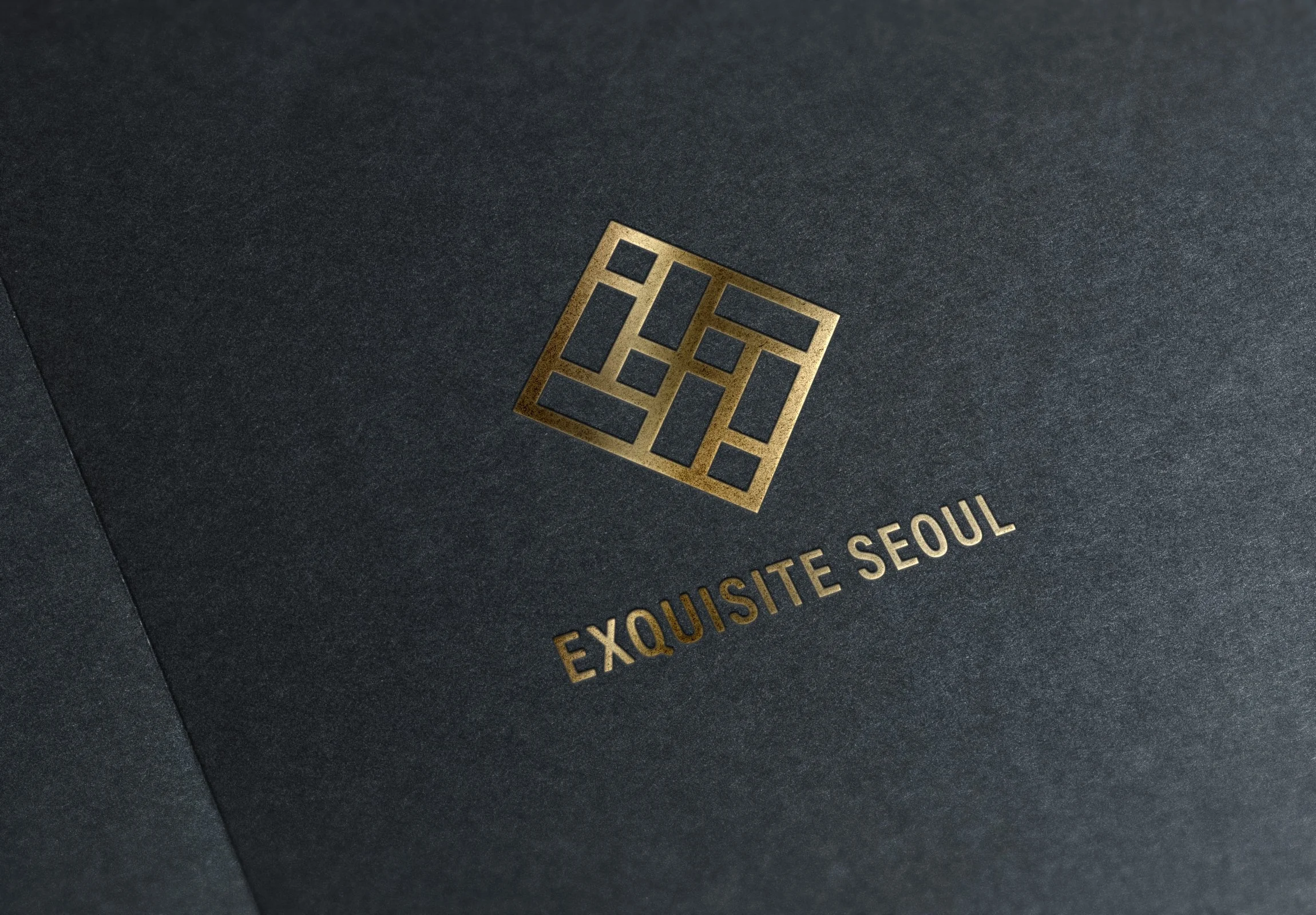 Black textured paper with a gold geometric logo and the text 'EXQUISITE SEOUL' printed in gold.