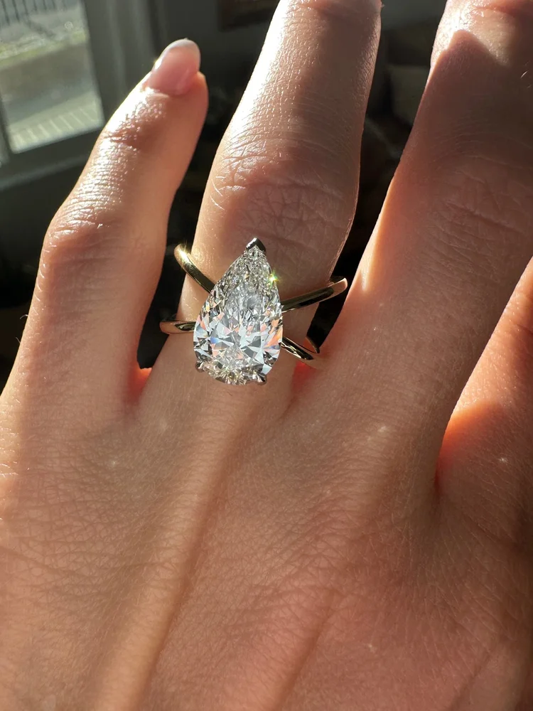 Pear-shaped diamond engagement ring on a hand